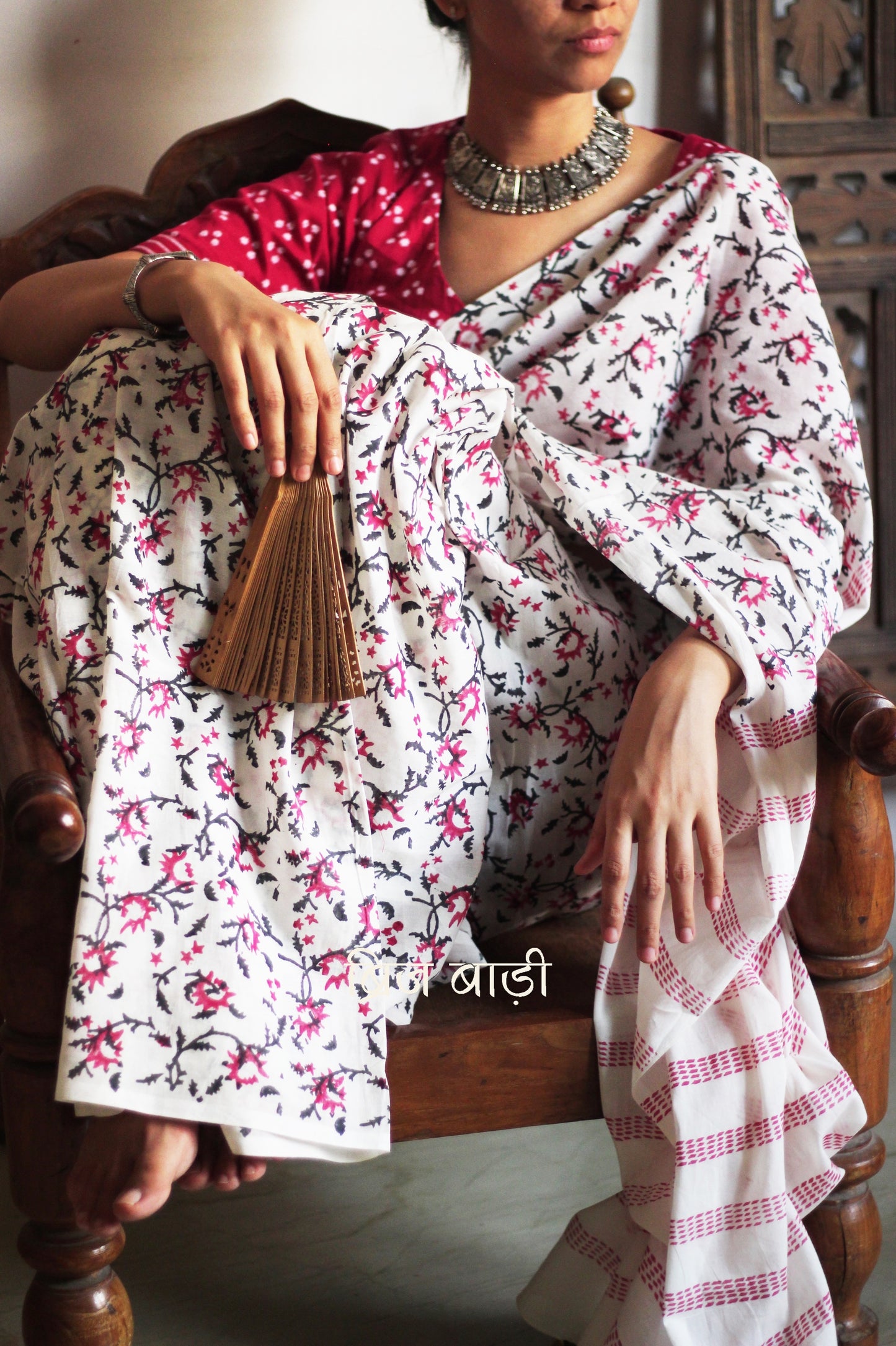 Off-white soft cotton saree by Brij Bari, hand block printed by skilled artisans with a striking floral pattern in pink and black for a fresh, elegant appeal. The saree is light-weight and breathableāideal for summer wear and everyday comfort. The pallu is detailed with handcrafted light green thread tassels, adding a subtle yet artistic finishing touch. Comes with a free hand block printed blouse piece that complements the sareeās colour palette. A versatile, handcrafted piece perfect for daily wear