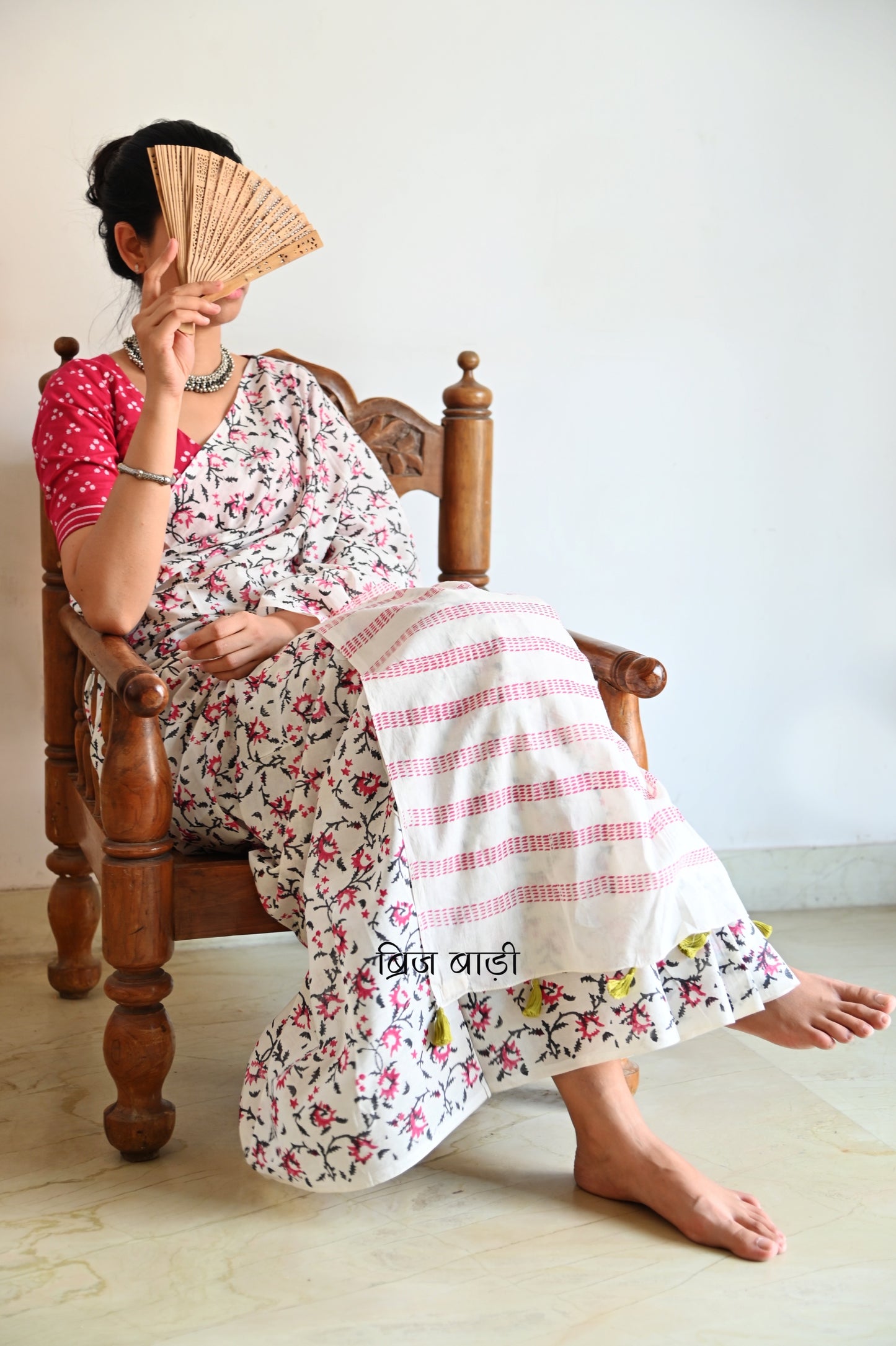Off-white soft cotton saree by Brij Bari, hand block printed by skilled artisans with a striking floral pattern in pink and black for a fresh, elegant appeal. The saree is light-weight and breathableāideal for summer wear and everyday comfort. The pallu is detailed with handcrafted light green thread tassels, adding a subtle yet artistic finishing touch. Comes with a free hand block printed blouse piece that complements the sareeās colour palette. A versatile, handcrafted piece perfect for daily wear
