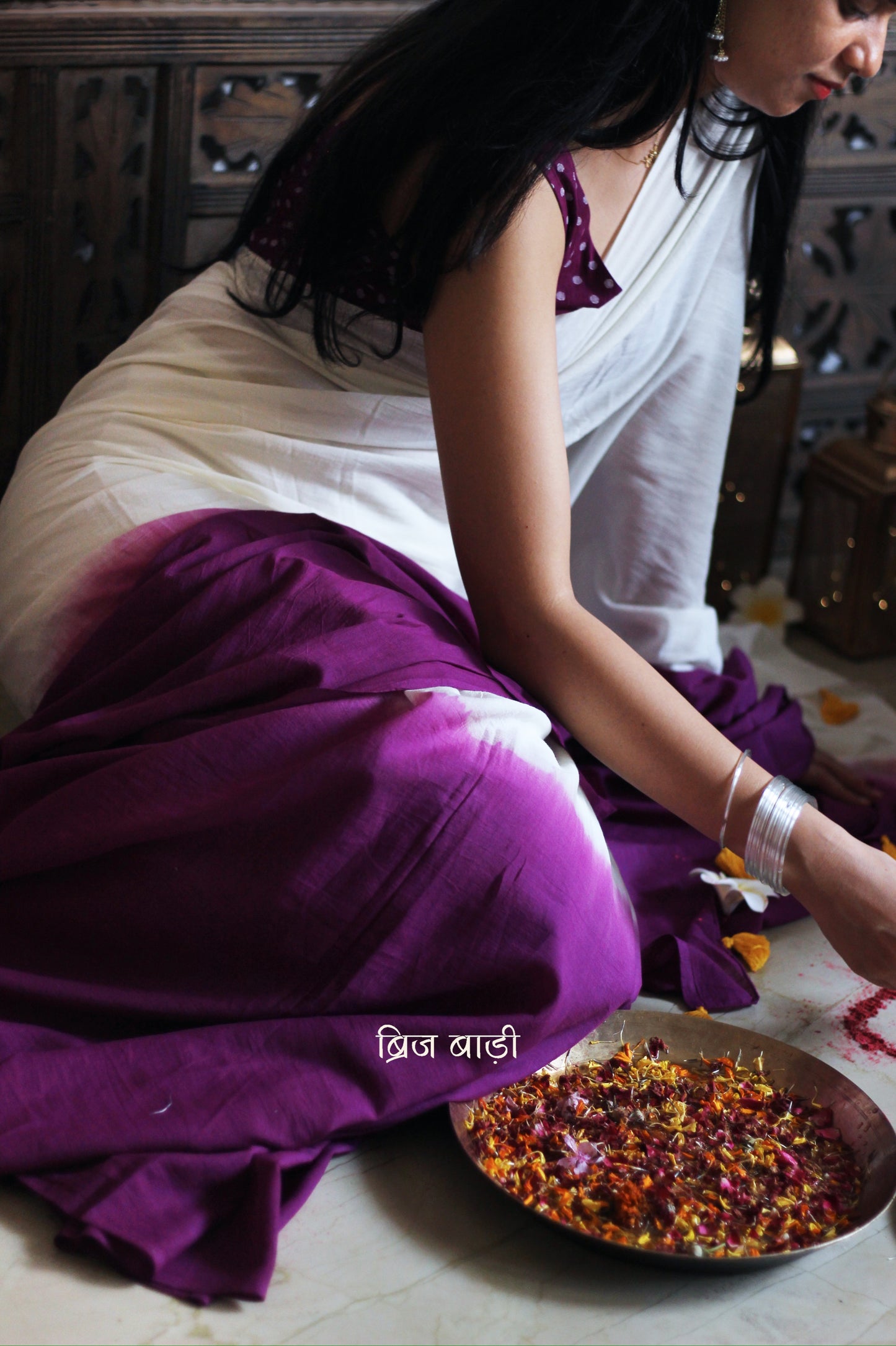 Purple and off-white ombré soft cotton saree by Brij Bari, crafted for effortless elegance and all-day comfort. The subtle blend of tones adds fluidity and grace to the drape, making it perfect for both everyday wear and special occasions. The pallu is adorned with handcrafted yellow thread tassels, lending a warm, artisanal touch. It comes with a free hand block printed blouse piece that complements the saree’s minimal yet striking aesthetic. Available in 8 beautiful colour options