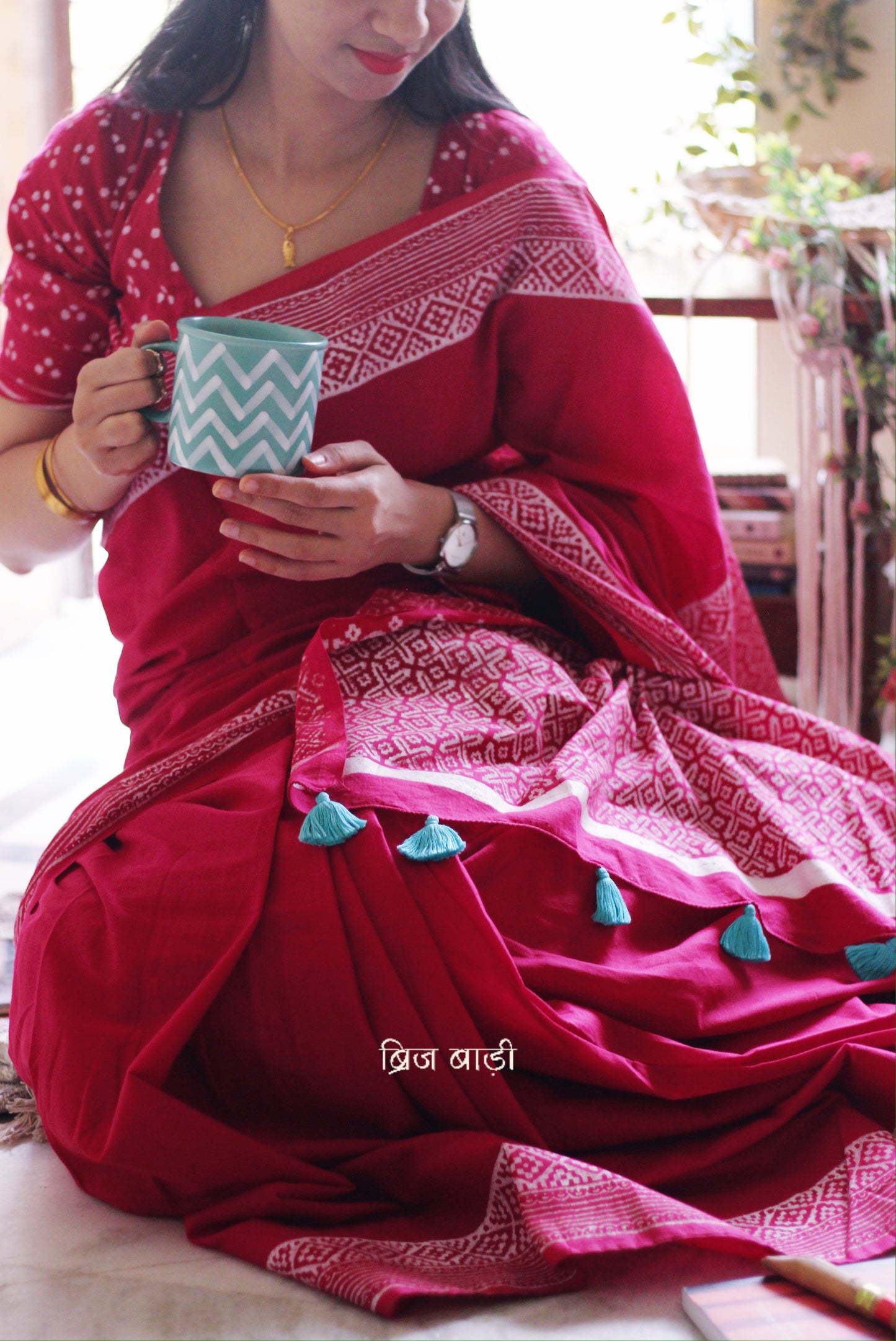 Soft and light-weight pink cotton saree by Brij Bari with intricate hand block printed detailing on the border and pallu for a refined, everyday aesthetic. Designed for effortless draping and breathable comfort this versatile saree is perfect for workdays, casual outings or understated occasions. Finished with delicate light blue handmade thread tassels on the pallu and paired with a free hand block printed blouse piece. A beautifully handcrafted daily wear staple from Brij Bari with free shipping pan India