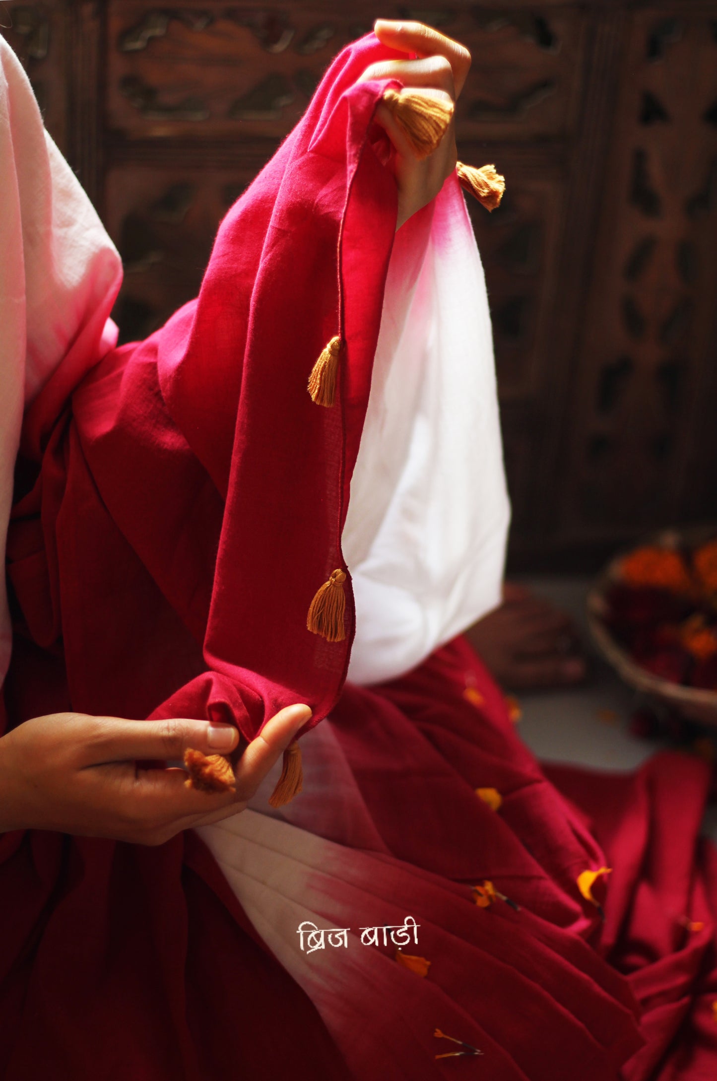 Red and off-white ombré soft cotton saree by Brij Bari, crafted for effortless elegance and all-day comfort. The subtle blend of tones adds fluidity and grace to the drape, making it perfect for both everyday wear and special occasions. The pallu is adorned with handcrafted mustard thread tassels, lending a warm, artisanal touch. It comes with a free hand block printed blouse piece that complements the saree’s minimal yet striking aesthetic. Available in 8 beautiful colour options