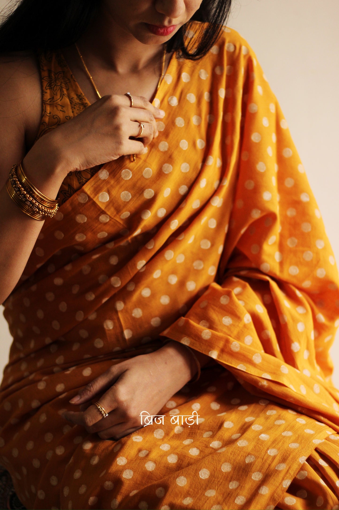 Yellow cotton saree with hand block printed polka dots, detailed with handmade thread tassels on the pallu. Includes a free soft cotton printed blouse piece.