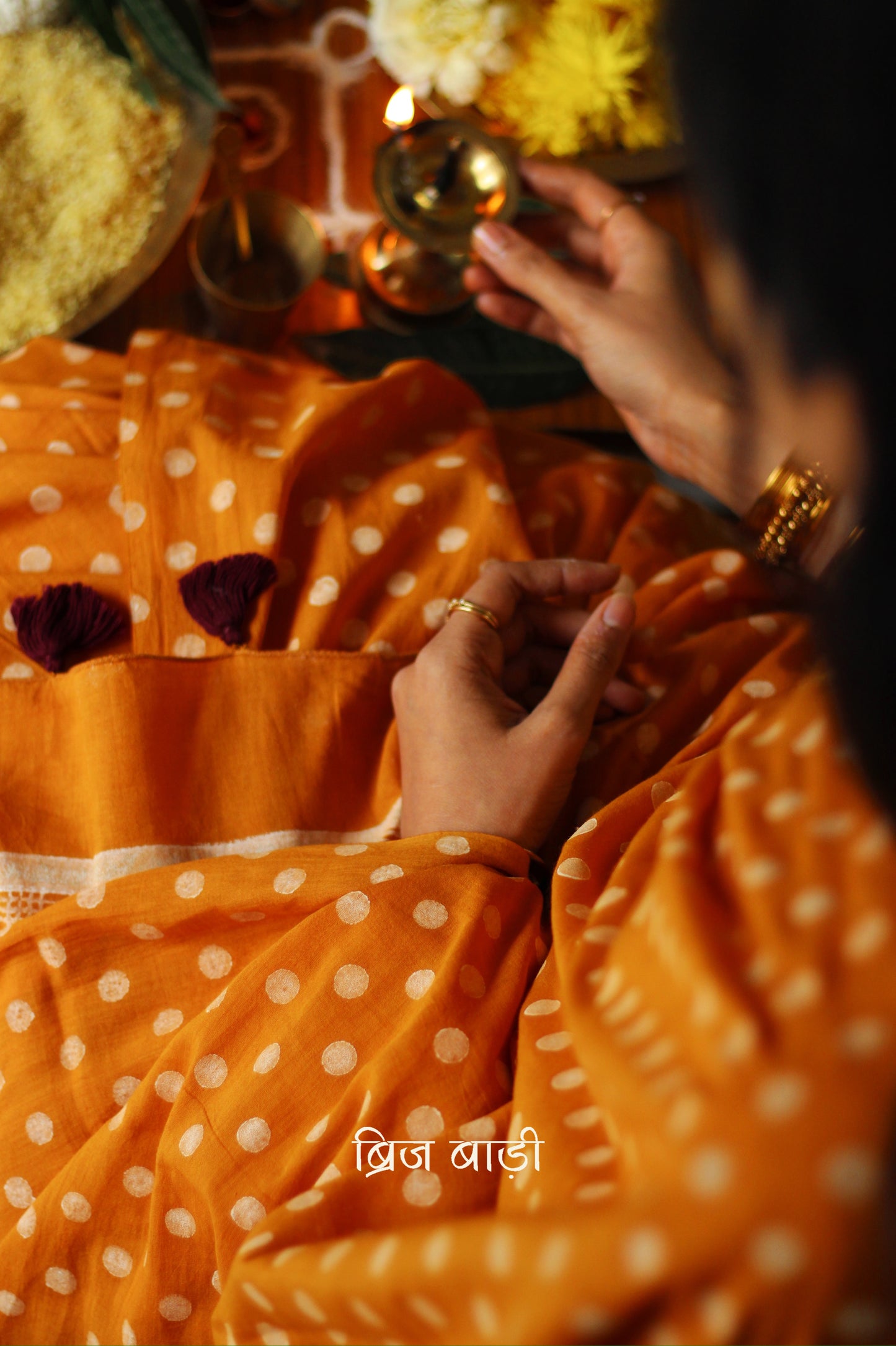 Yellow cotton saree with hand block printed polka dots, detailed with handmade thread tassels on the pallu. Includes a free soft cotton printed blouse piece.