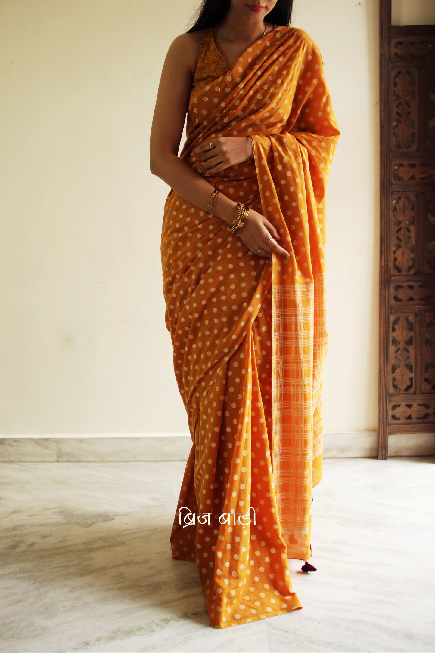 Yellow cotton saree with hand block printed polka dots, detailed with handmade thread tassels on the pallu. Includes a free soft cotton printed blouse piece.