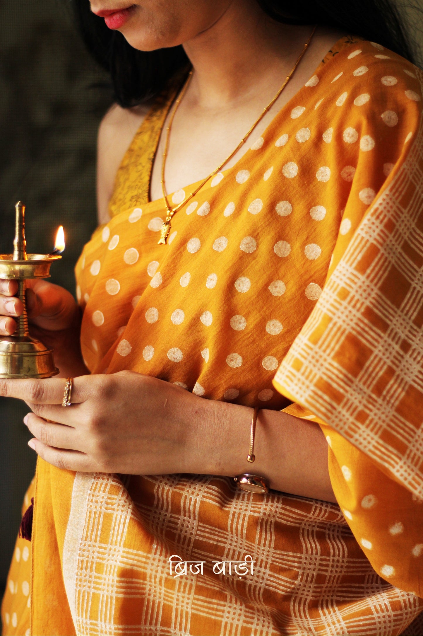 Yellow cotton saree with hand block printed polka dots, detailed with handmade thread tassels on the pallu. Includes a free soft cotton printed blouse piece.
