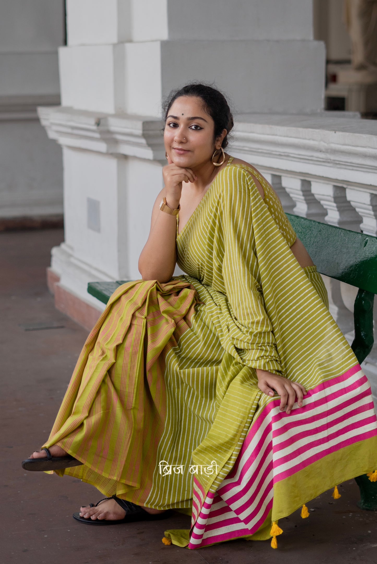 Light green soft and lightweight cotton saree by Brij Bari, hand block printed with pink and white stripe pattern. Finished with handmade yellow thread tassels on the pallu. Includes a free block printed cotton blouse piece. A versatile saree designed to add a vibrant pop of colour to your everyday wardrobe while ensuring breathable comfort and effortless style. Free shipping pan India.