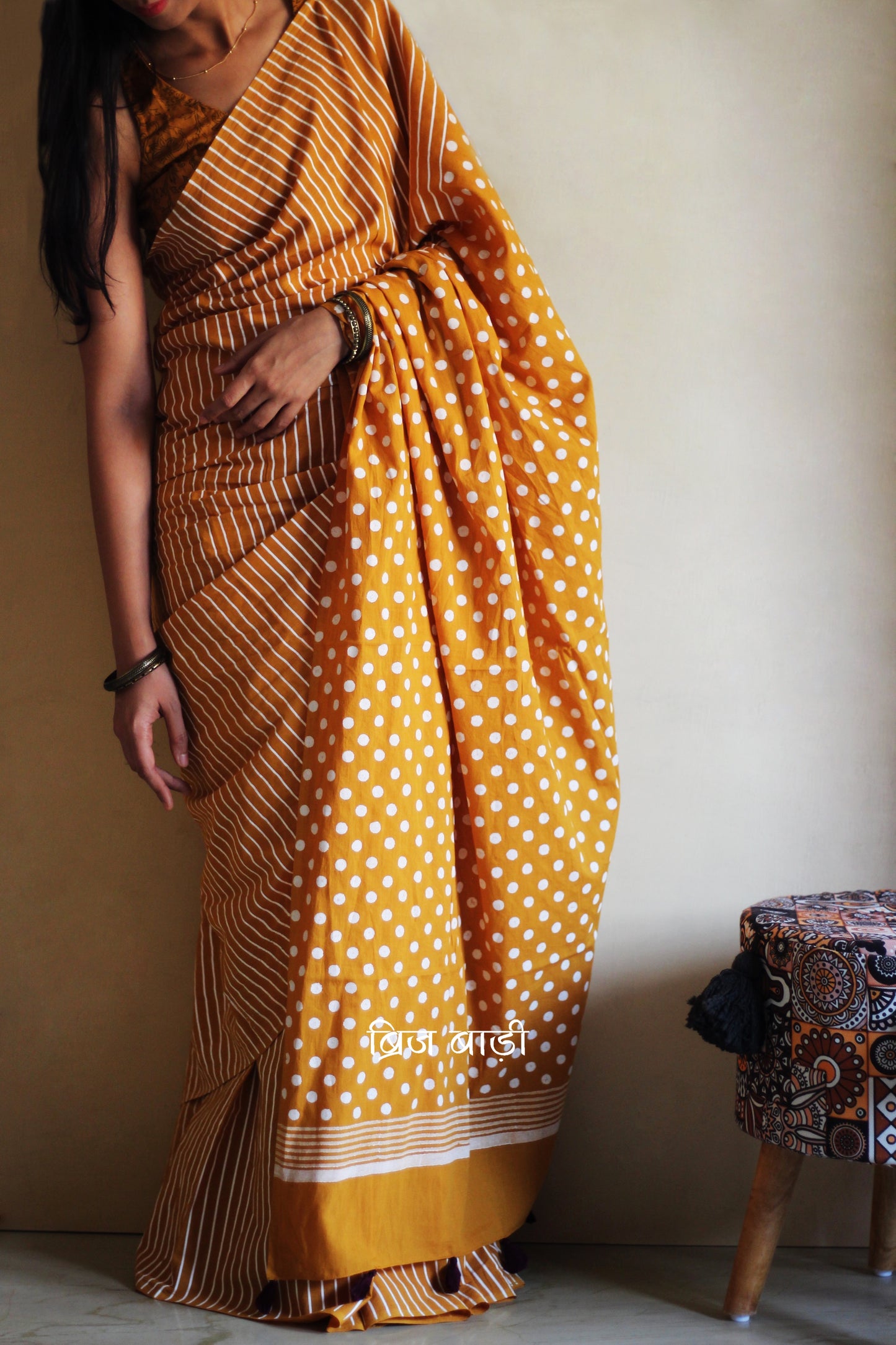 Yellow cotton saree by Brij Bari with bold hand block printed stripe and polka dot design. Artisan-crafted, breathable fabric with matching blouse piece.