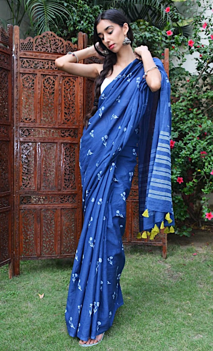 Blue hand block printed cotton saree with intricate floral motifs, lightweight and breathable fabric, includes a free matching blouse piece – perfect for everyday and festive wear.