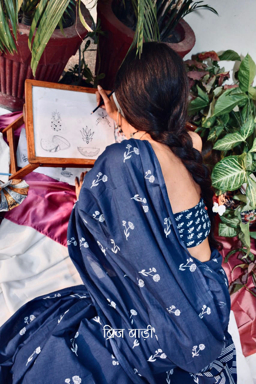 Blue hand block printed cotton saree with intricate floral motifs, lightweight and breathable fabric, includes a free matching blouse piece – perfect for everyday and festive wear.