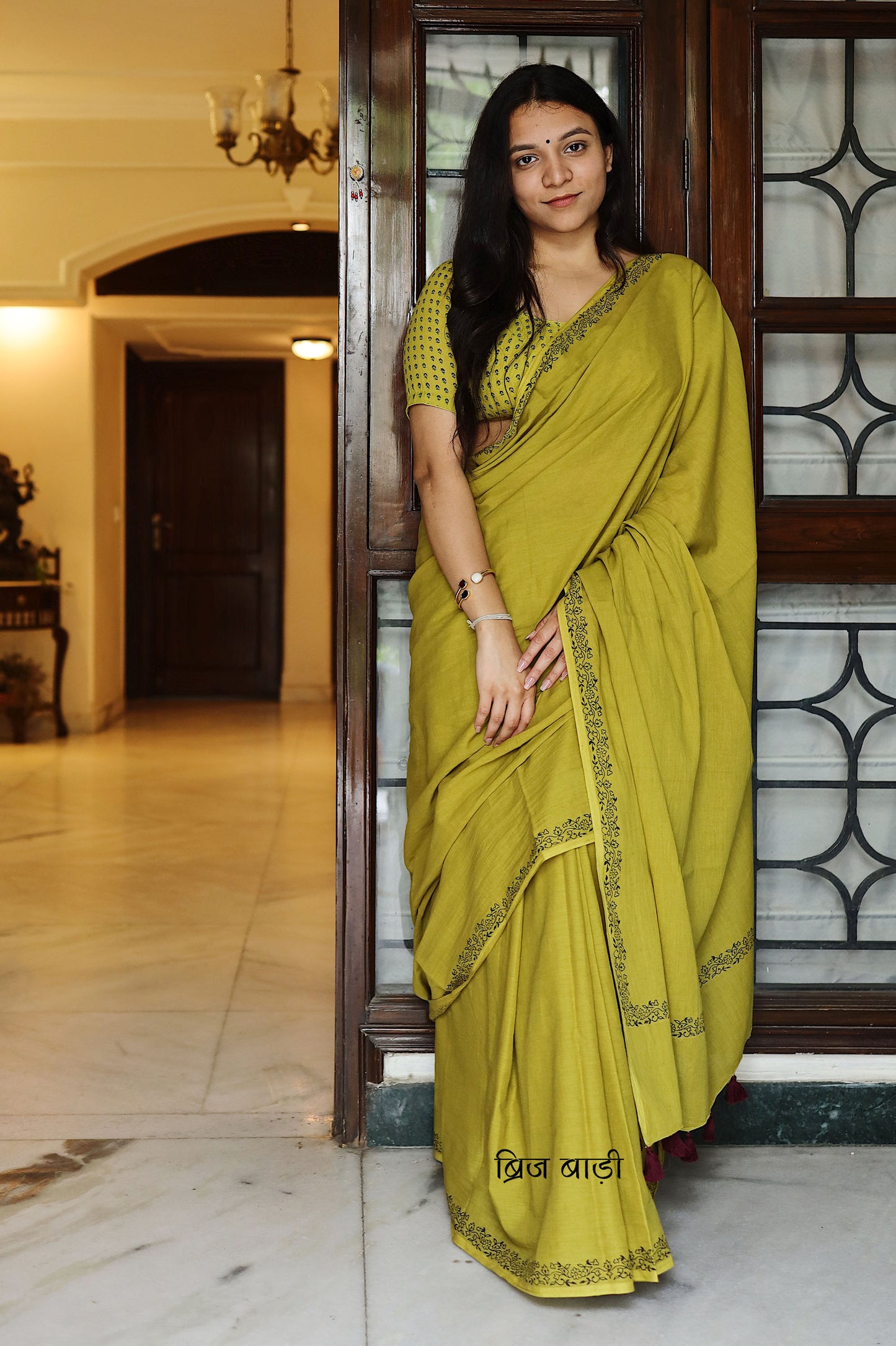 Light green soft and light-weight cotton saree by Brij Bari with a simple & elegant hand block printed border in classic black. Crafted in breathable, airy cotton, this saree is ideal for everyday wear — offering ease, comfort, and timeless style for work, casual days or relaxed occasions. The pallu is beautifully finished with purple handmade thread tassels, adding a playful, artisanal touch. It comes with a free hand block printed blouse piece