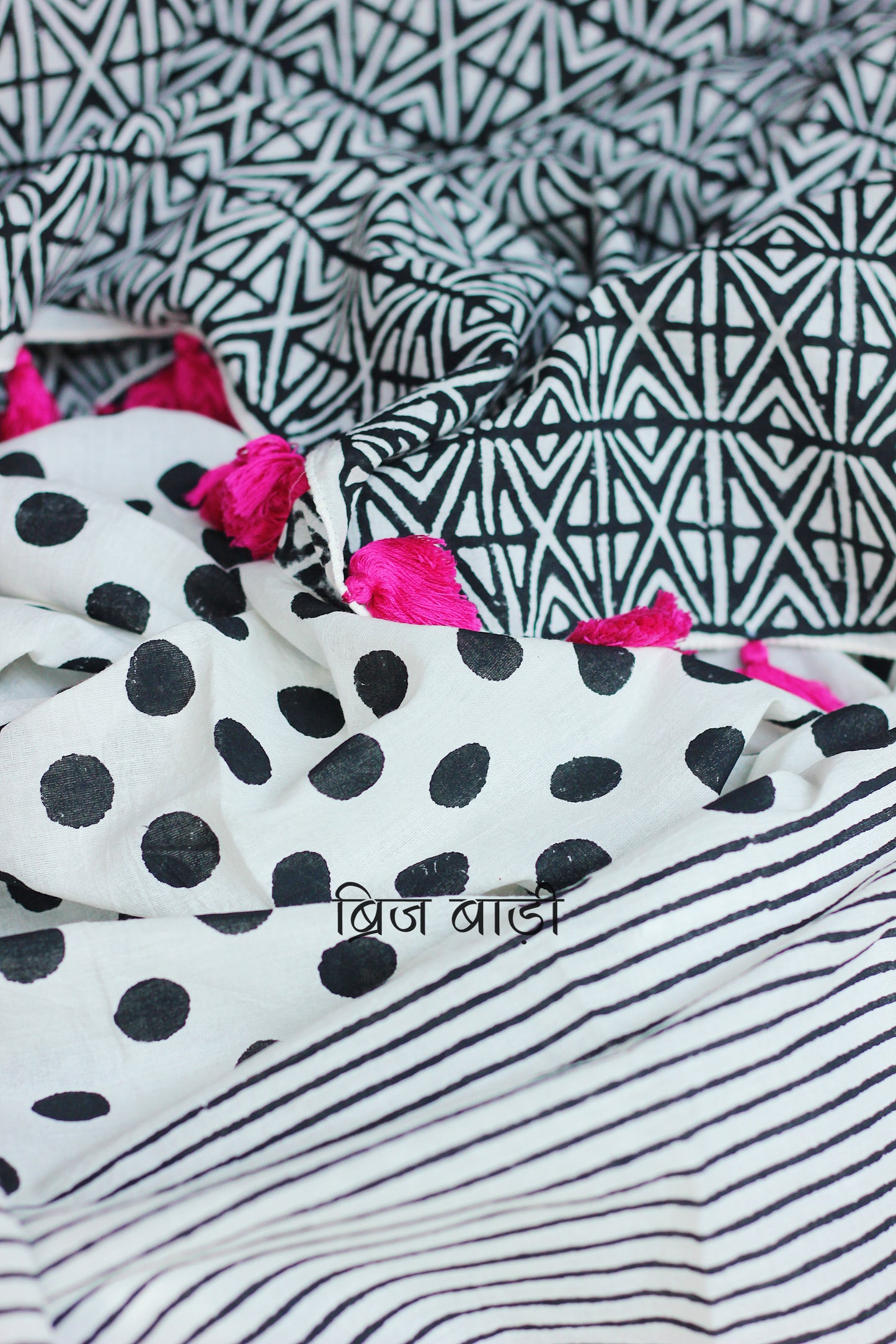 Off-white soft and light-weight cotton saree by Brij Bari with a striking combination of hand block printed stripes and polka dots for a playful yet modern aesthetic. Crafted from breathable cotton, this saree is designed for daily wear—light, comfortable, and effortlessly stylish. The pallu is detailed with handcrafted pink thread tassels adding a pop of colour and artisanal finish. Includes a free hand block printed blouse piece that compliments the saree. Ships free pan India by Brij Bari.