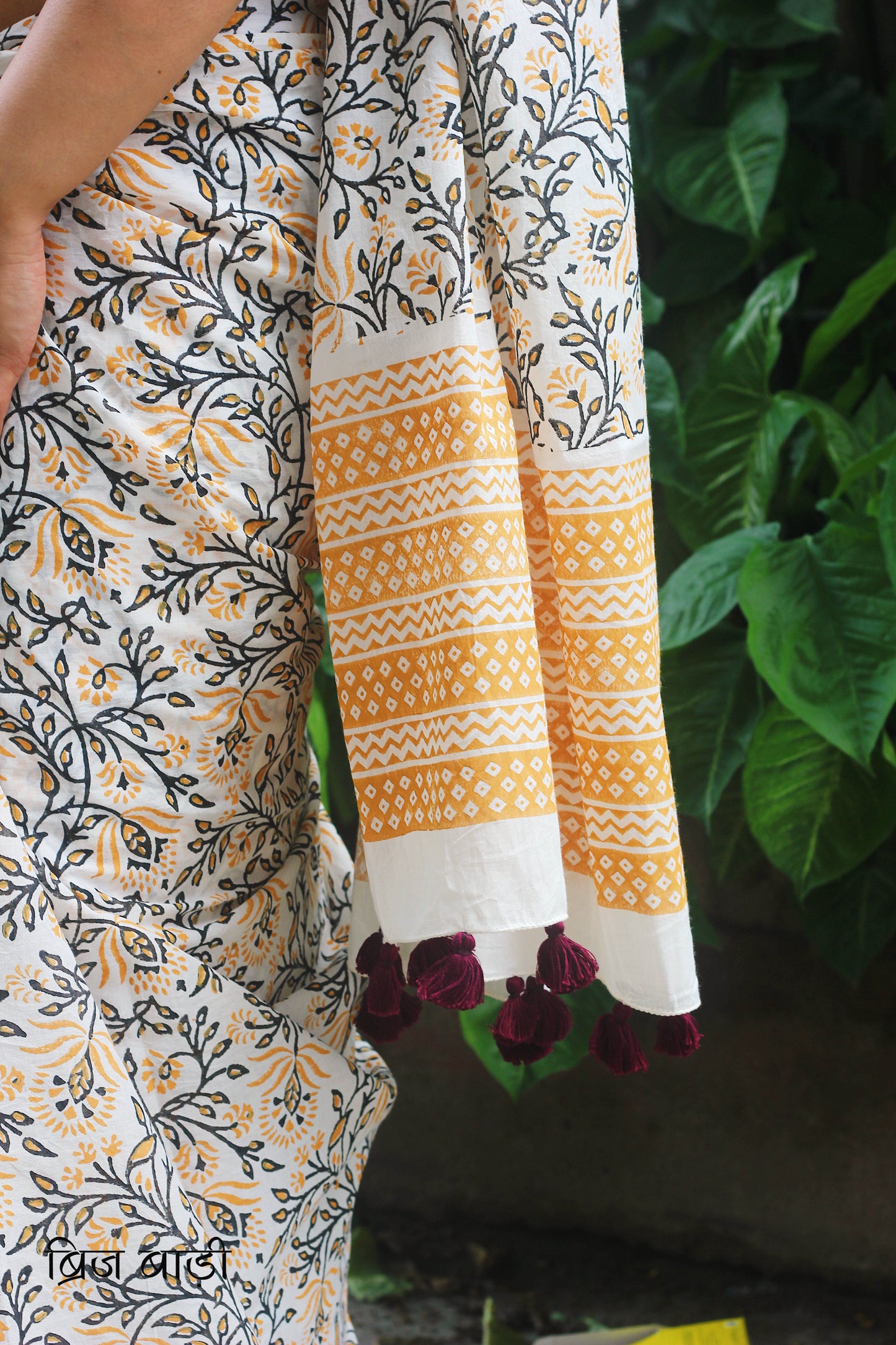 Yellow cotton saree with floral hand block prints, artisan- handcrafted with handmade thread tassels on pallu. Comes with a soft, breathable printed blouse piece.
