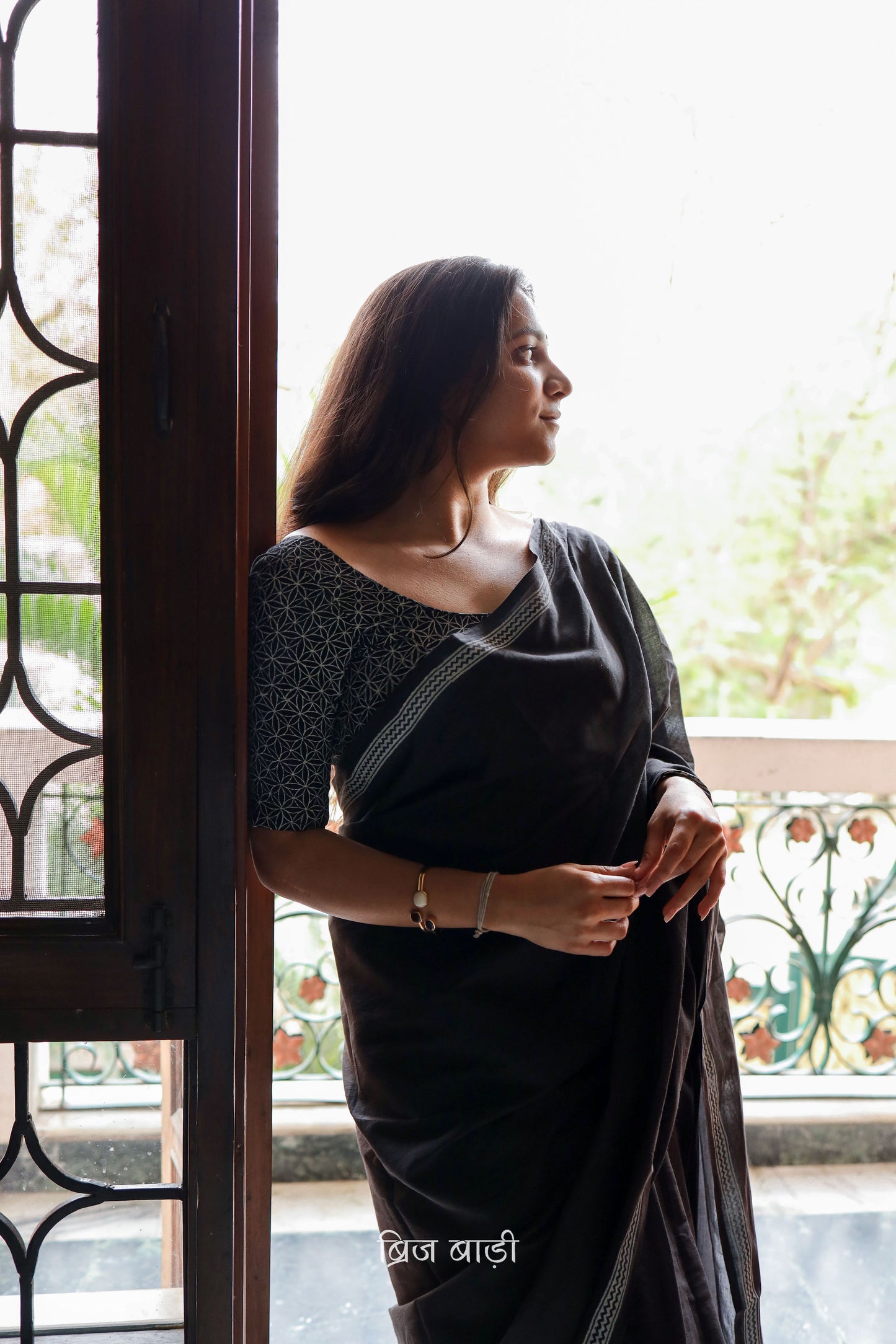 Black soft and light-weight cotton saree by Brij Bari with a simple and elegant hand block printed border in white for a timeless minimal look. Made from breathable, easy-to-drape cotton, this saree is perfect for everyday wear, offering effortless style & comfort. Pallu is finished with handmade mustard thread tassels, adding a handcrafted detail and a pop of colour. Includes a free hand block printed blouse piece designed to complement the sar the saree’s clean, classic border design.