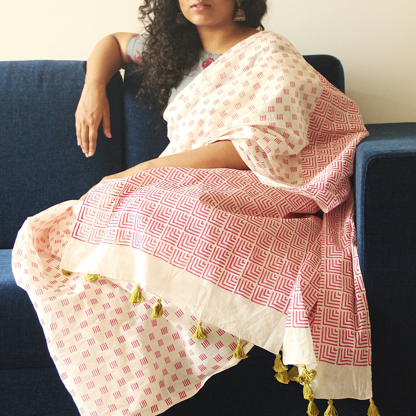 Off-white soft and light-weight cotton saree by Brij Bari, hand block printed with a delicate and modern geometrical pattern in a vibrant shade of pink. Crafted for everyday ease and summer comfort, the saree features handcrafted light green thread tassels on the pallu that add a subtle artisanal detail. Comes with a free hand block printed blouse piece to complete the look. A perfect lightweight pick for both casual wear and low-key festive moments. Free shipping across India.