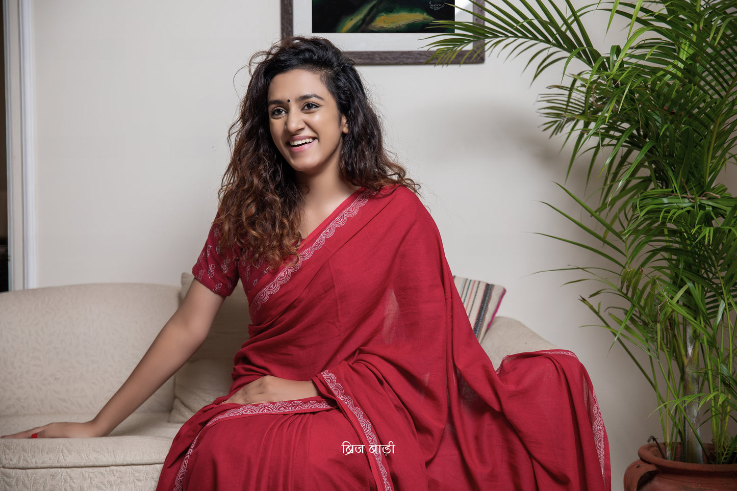 Deep red soft and light-weight cotton saree by Brij Bari with a delicate white hand block printed border. Detailed with mustard handmade thread tassels on the pallu and paired with a free block printed blouse piece. A versatile, breathable saree perfect for everyday wear, with free shipping pan India.