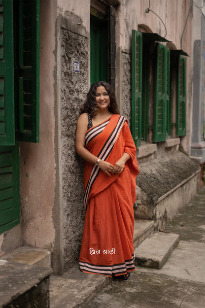 Anindita Rust Orange cotton saree with black and white stripe hand block printed border