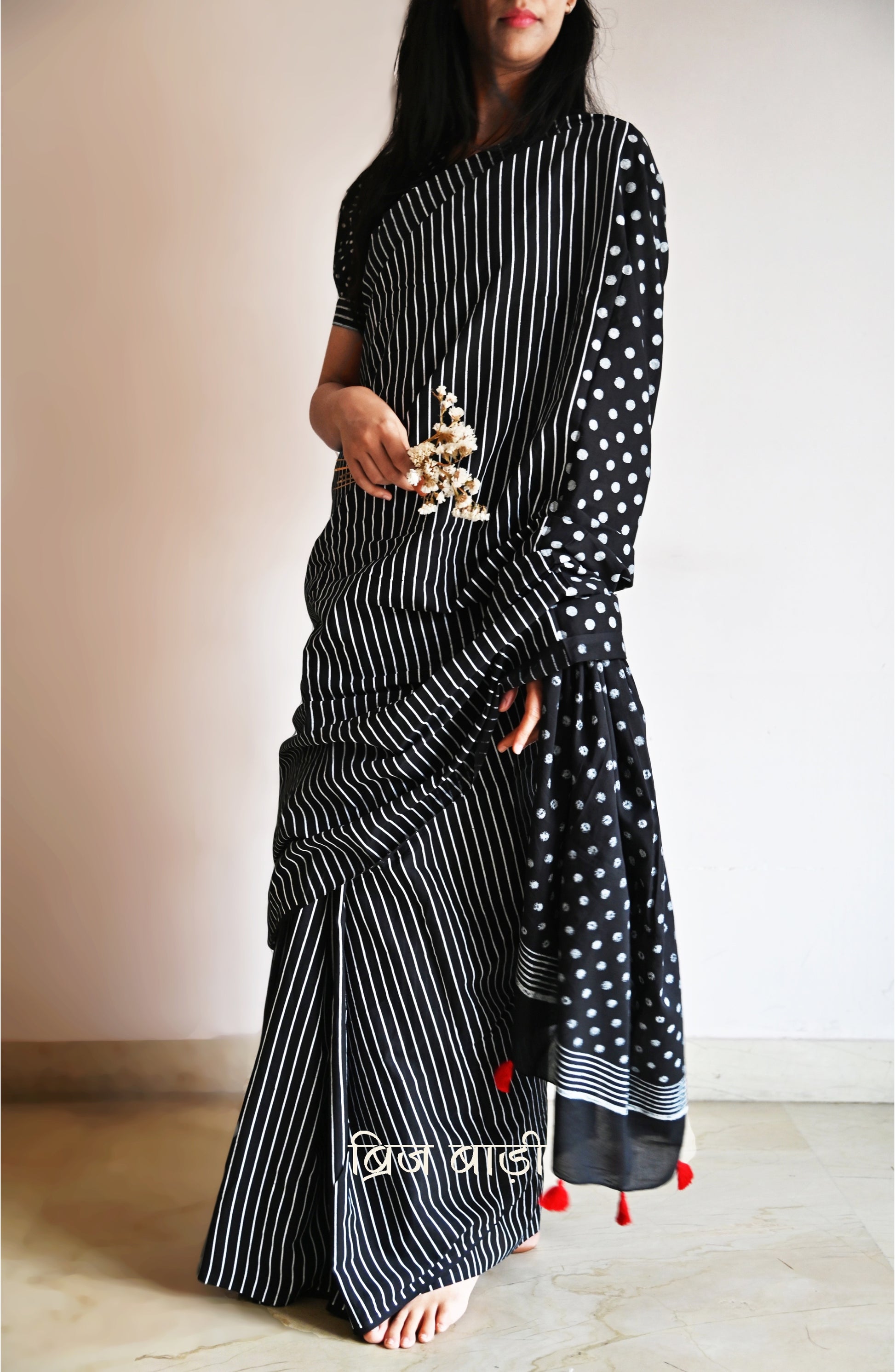 Black cotton saree by Brij Bari with bold hand block printed stripe and polka dot design. Artisan-crafted, breathable fabric with matching blouse piece.