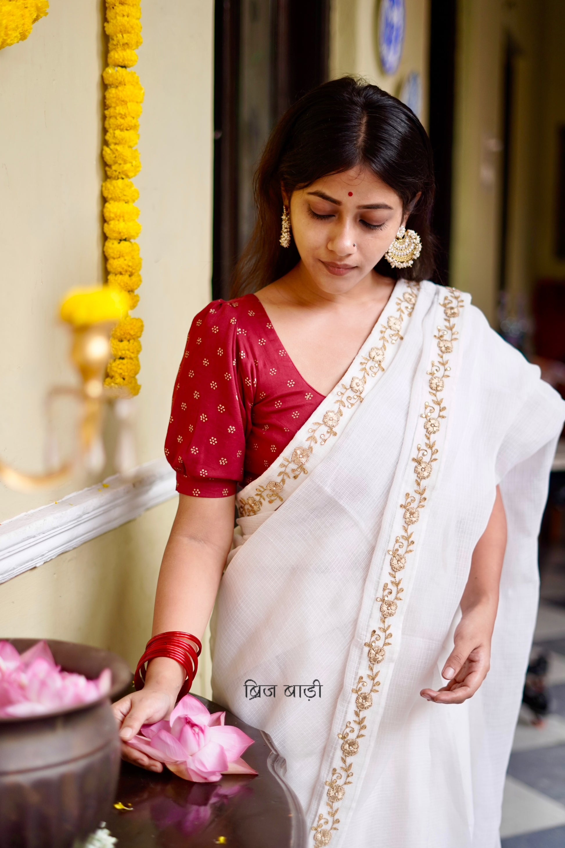 Ganga handwoven off-white Kota Doria saree with hand-embroidered border and thread tassel with ghungroo detailing on palla