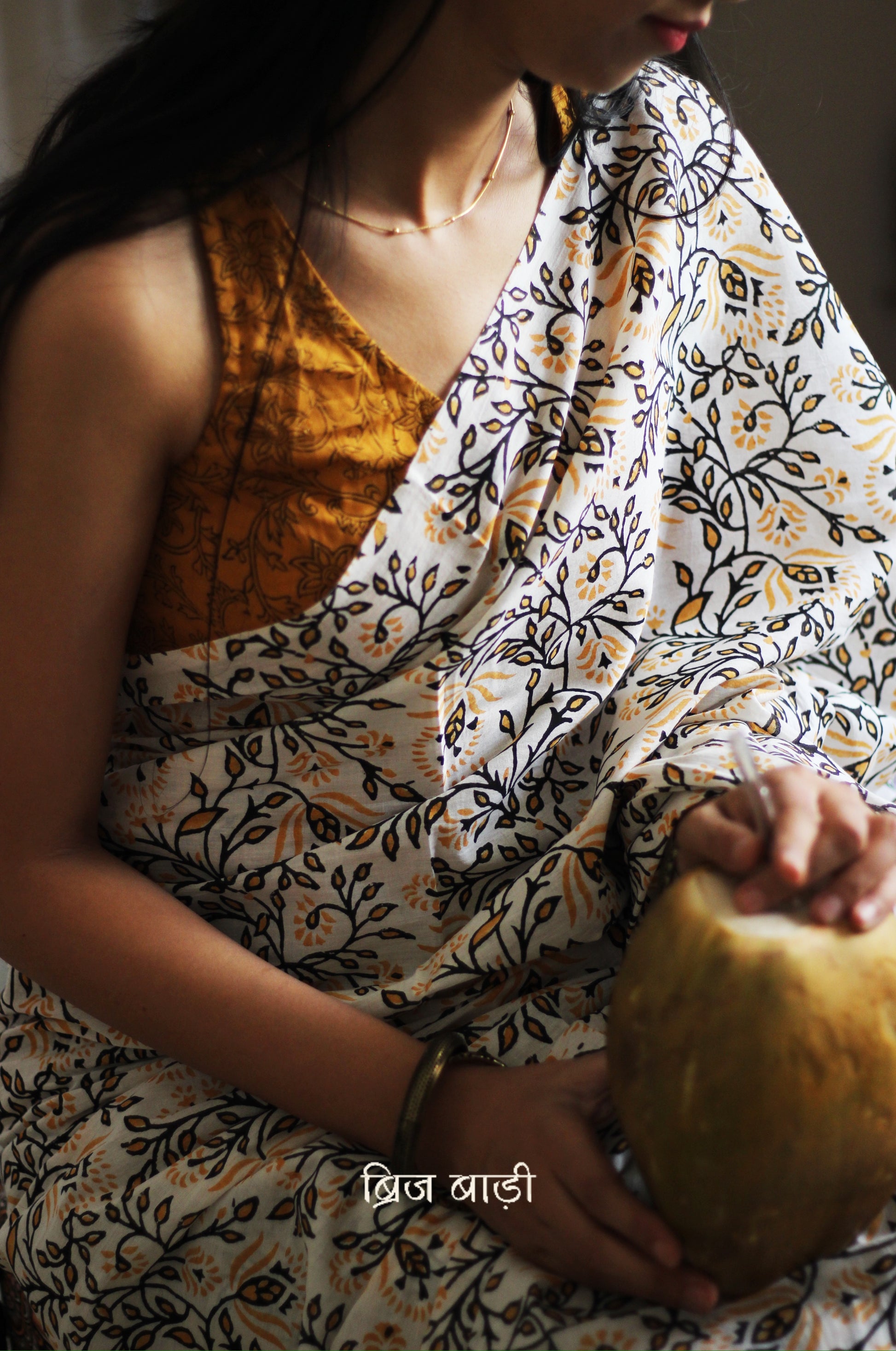 Yellow cotton saree with floral hand block prints, artisan- handcrafted with handmade thread tassels on pallu. Comes with a soft, breathable printed blouse piece.