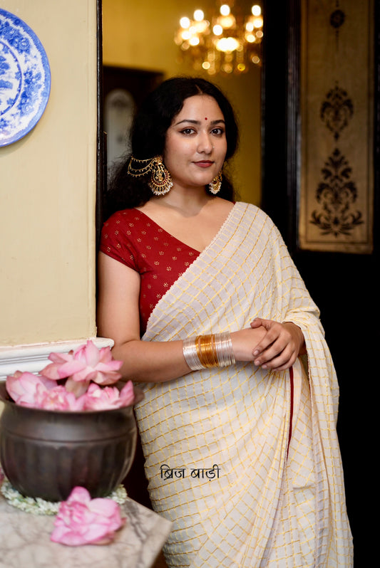 Gomti off-white cotton saree with gold checks and crochet lace detailing with handmade thread tassel & ghungroo detailing on the palla