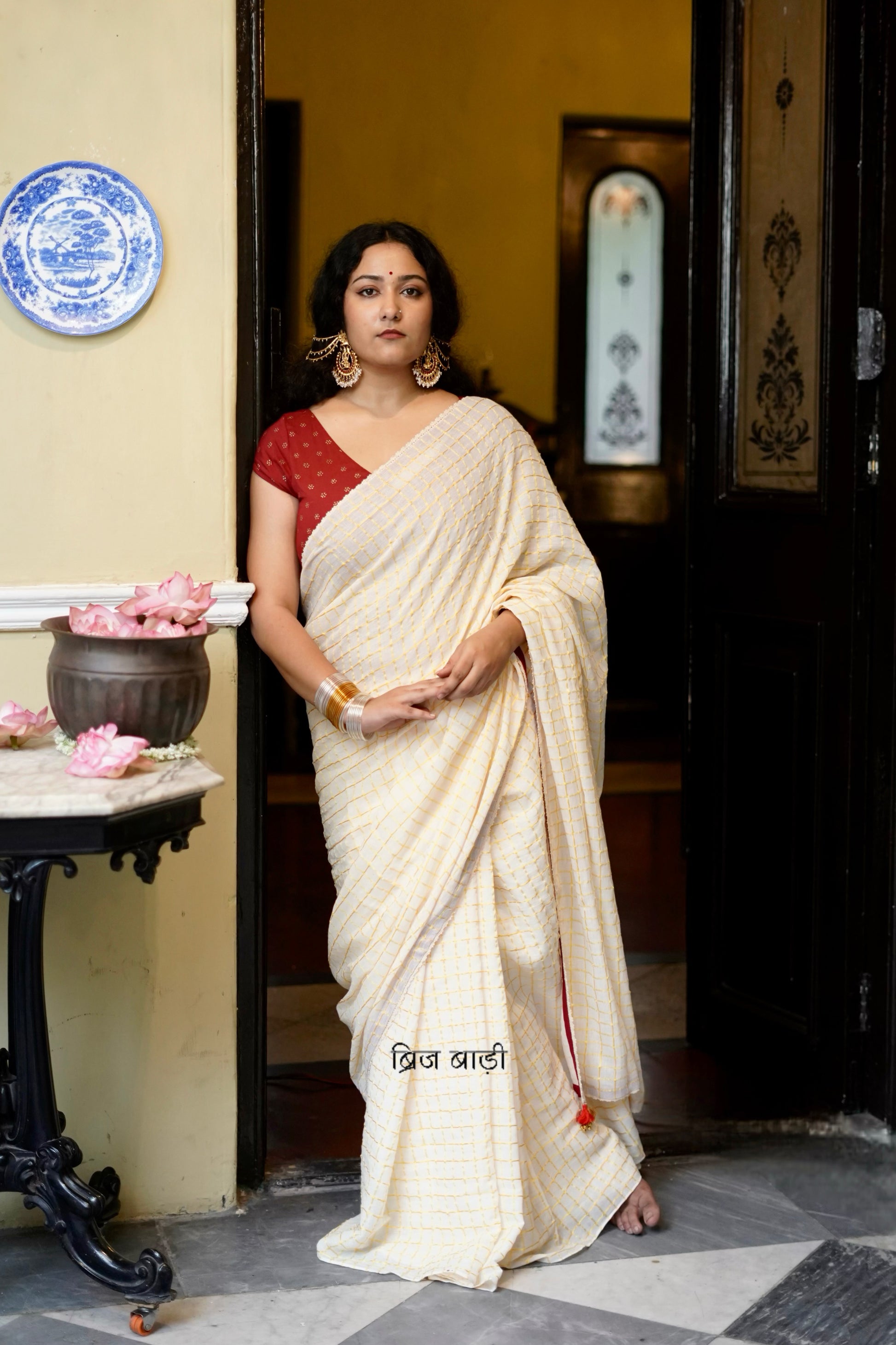 Gomti off-white cotton saree with gold checks and crochet lace detailing with handmade thread tassel & ghungroo detailing on the palla