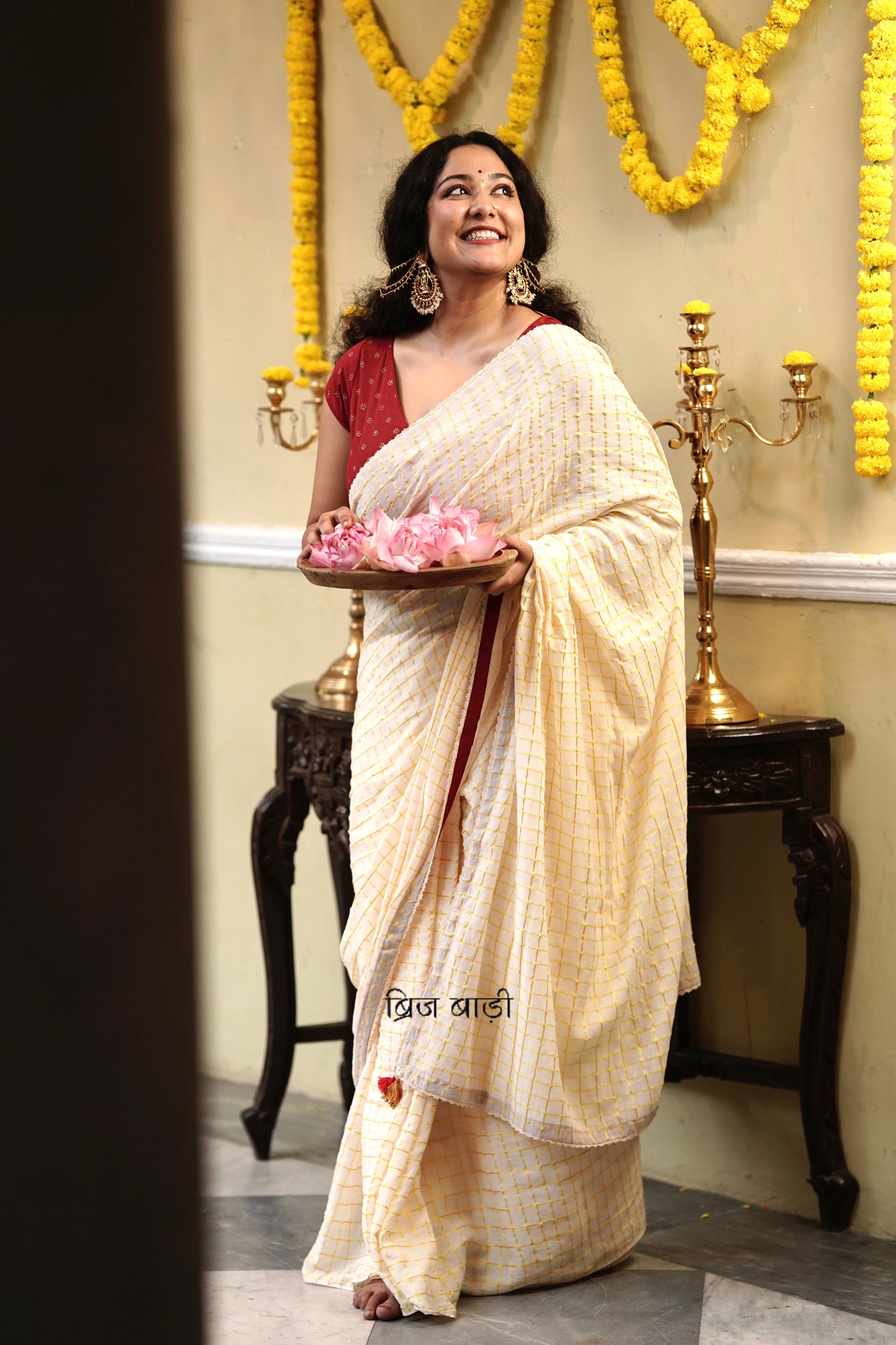 Gomti off-white cotton saree with gold checks and crochet lace detailing with handmade thread tassel & ghungroo detailing on the palla