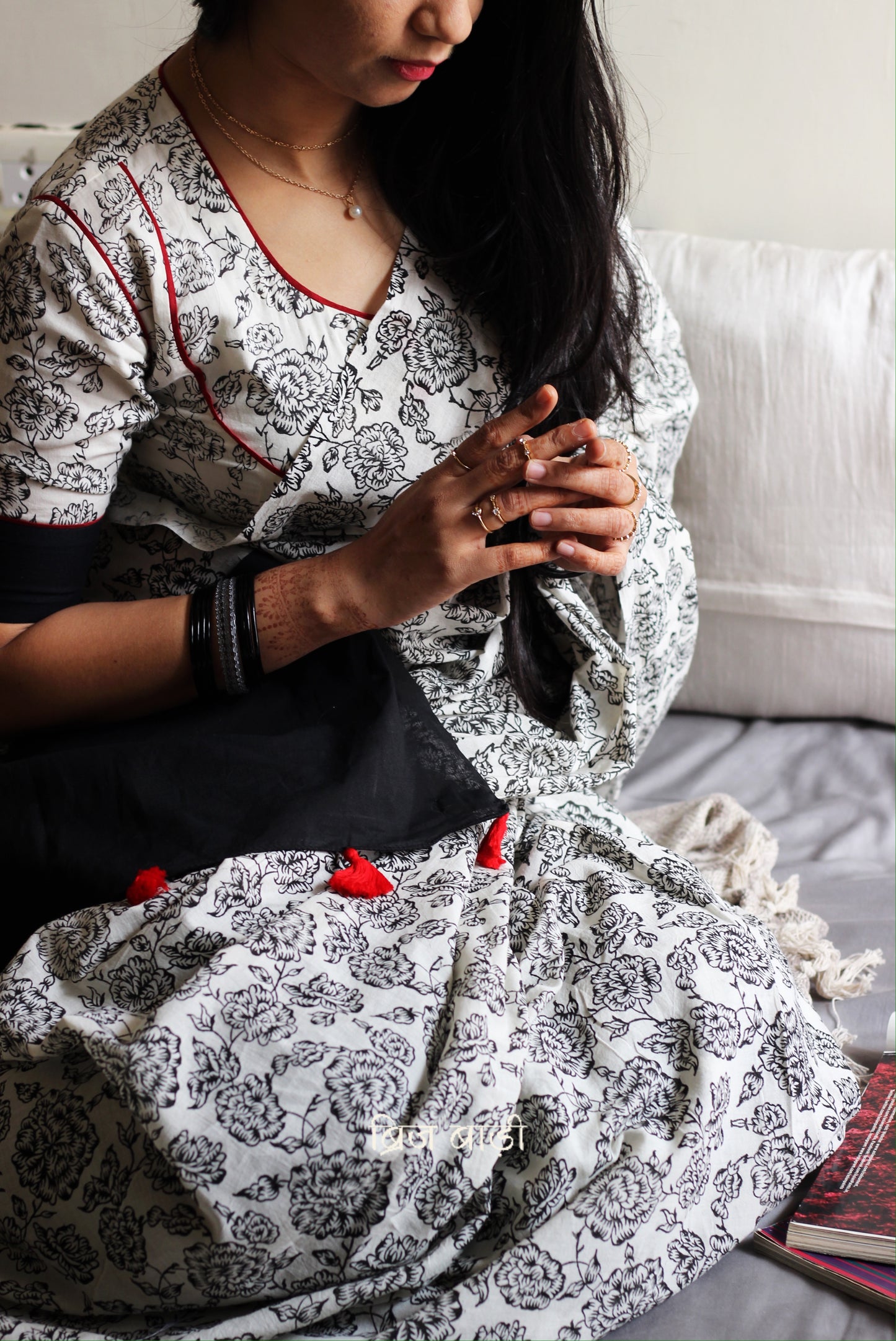 Off-white soft and light-weight cotton saree by Brij Bari, hand block printed with a delicate rose pattern for an elegant, understated everyday look. Crafted from breathable cotton, this saree ensures comfort and ease of wear, ideal for workdays, casual gatherings or daily summer dressing. The pallu is finished with red handmade thread tassels adding a traditional handcrafted detail to the look. Comes with a free hand block printed blouse piece designed to perfectly compliment the saree. 
