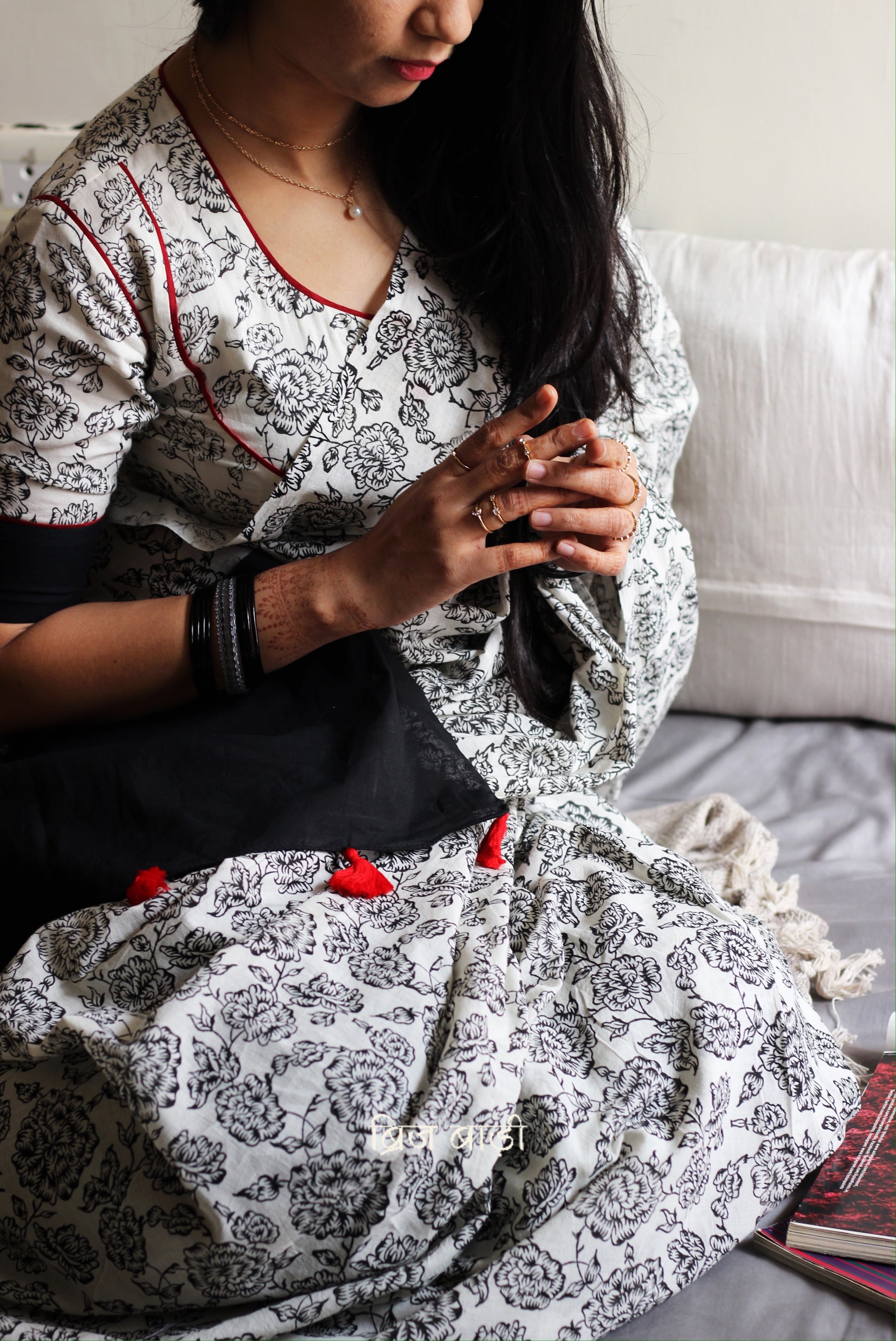 Off-white soft and light-weight cotton saree by Brij Bari, hand block printed with a delicate rose pattern for an elegant, understated everyday look. Crafted from breathable cotton, this saree ensures comfort and ease of wear, ideal for workdays, casual gatherings or daily summer dressing. The pallu is finished with red handmade thread tassels adding a traditional handcrafted detail to the look. Comes with a free hand block printed blouse piece designed to perfectly compliment the saree. 