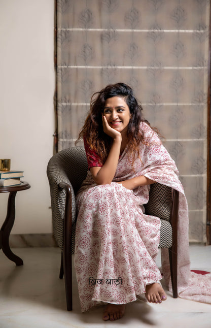 Off-white soft and light-weight cotton saree by Brij Bari, hand block printed with a delicate rose pattern for an elegant, understated everyday look. Crafted from breathable cotton, this saree ensures comfort and ease of wear, ideal for workdays, casual gatherings or daily summer dressing. The pallu is finished with bright olive green handmade thread tassels adding a traditional handcrafted detail to the look. Comes with a free hand block printed blouse piece designed to perfectly compliment the saree. 