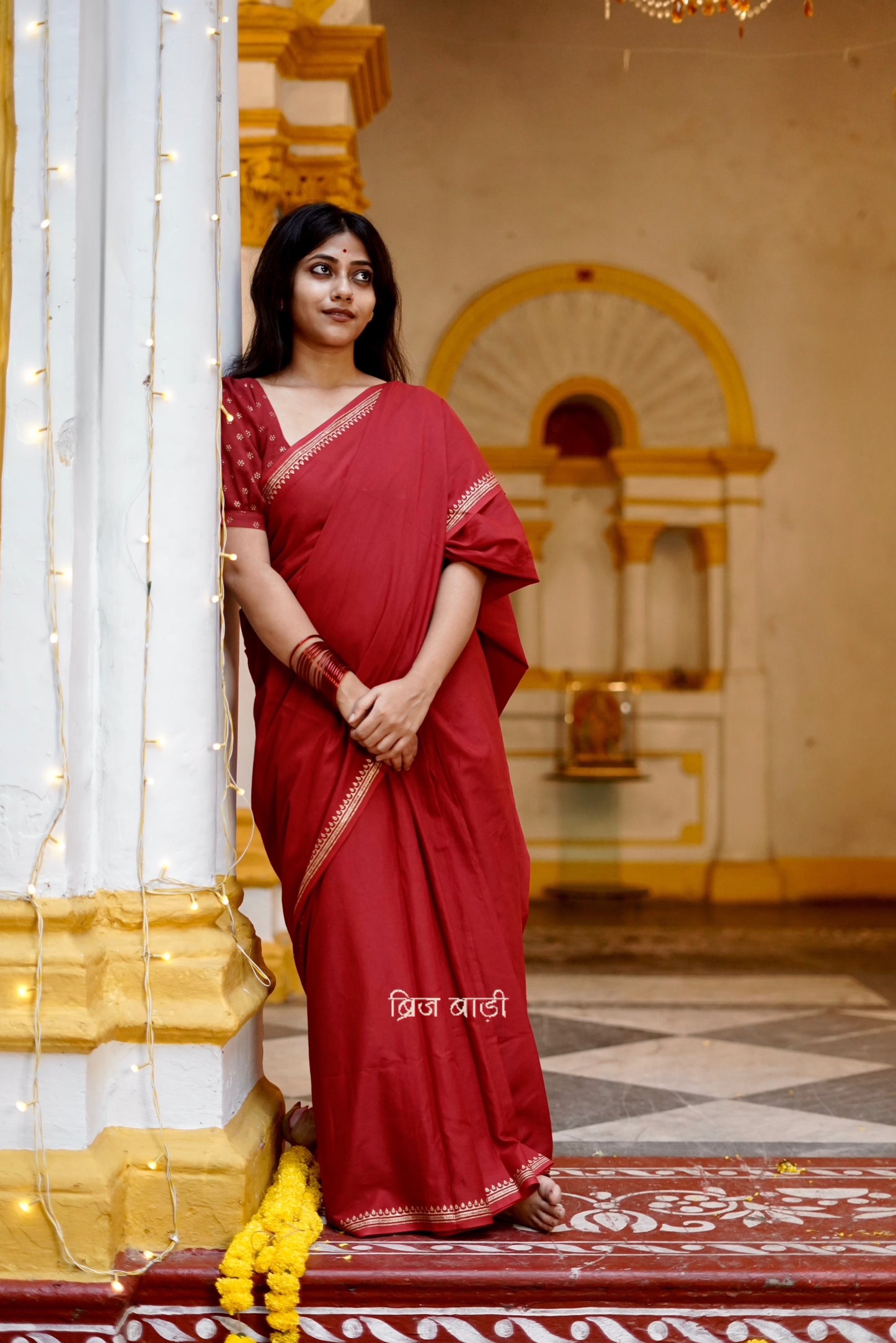 Iravati deep red cotton saree with hand block-printed gold border and handmade thread tassel on pallu