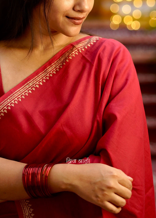 Iravati deep red cotton saree with hand block-printed gold border and handmade thread tassel on pallu