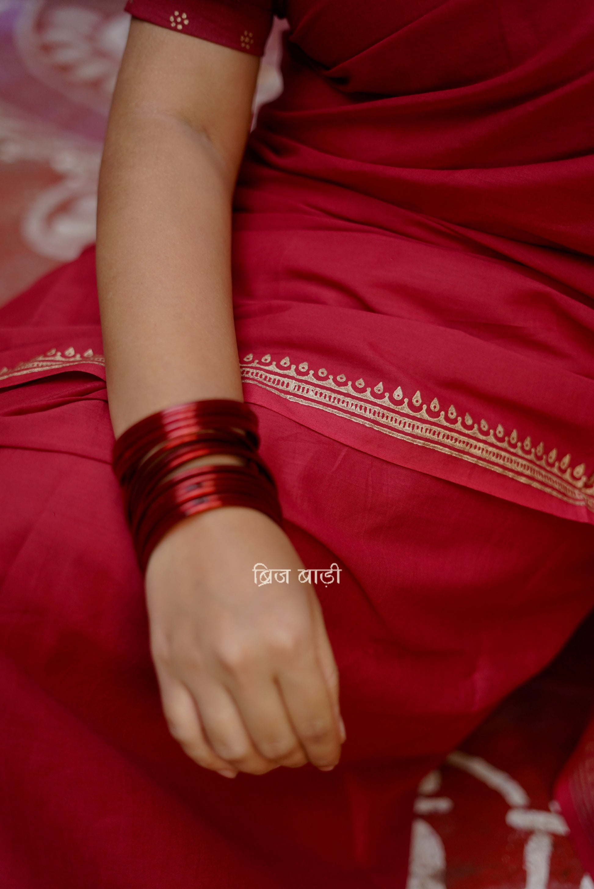 Iravati deep red cotton saree with hand block-printed gold border and handmade thread tassel on pallu