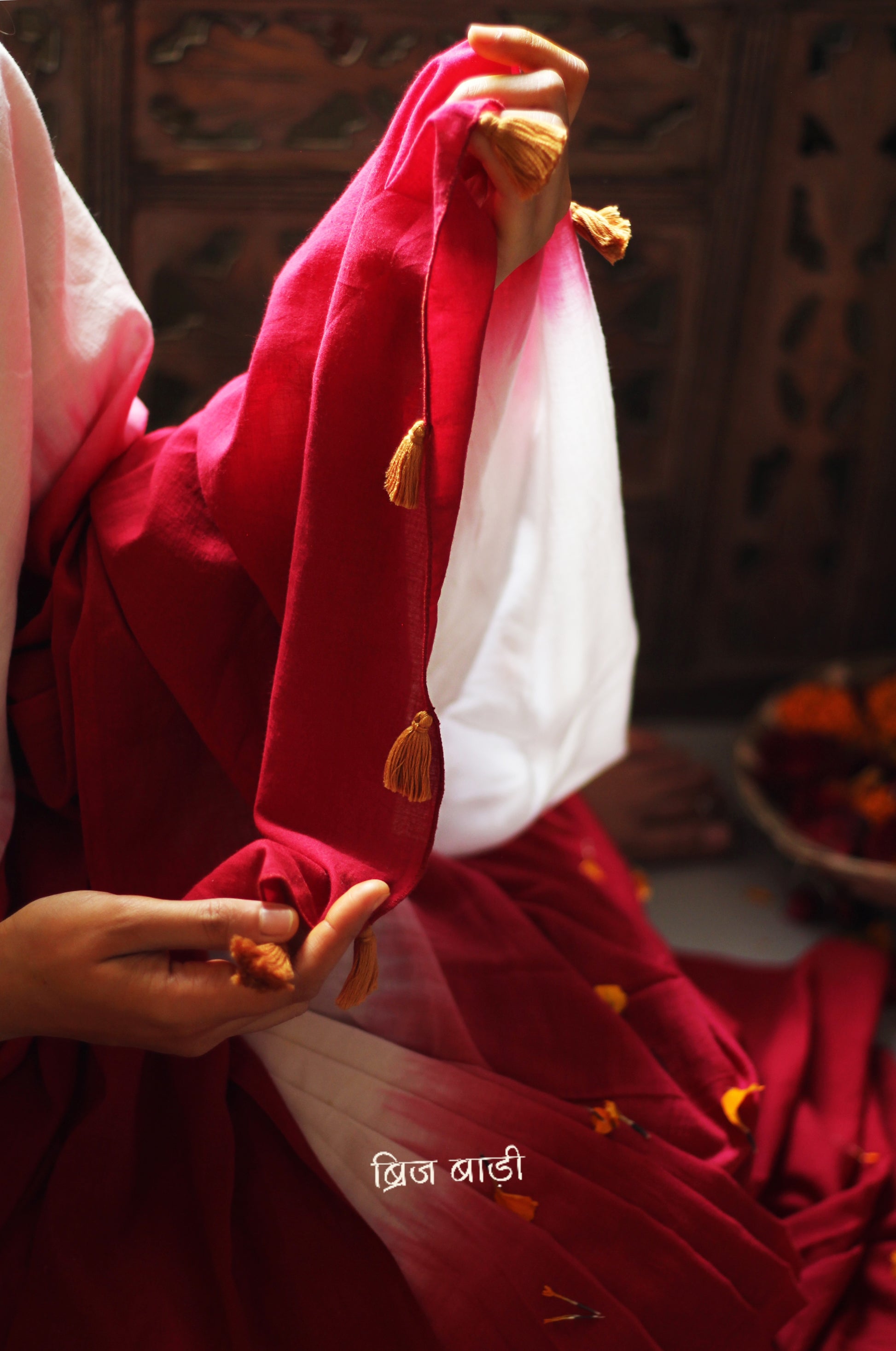 Red and off-white ombré soft cotton saree by Brij Bari, crafted for effortless elegance and all-day comfort. The subtle blend of tones adds fluidity and grace to the drape, making it perfect for both everyday wear and special occasions. The pallu is adorned with handcrafted mustard thread tassels, lending a warm, artisanal touch. It comes with a free hand block printed blouse piece that complements the saree’s minimal yet striking aesthetic. Available in 8 beautiful colour options