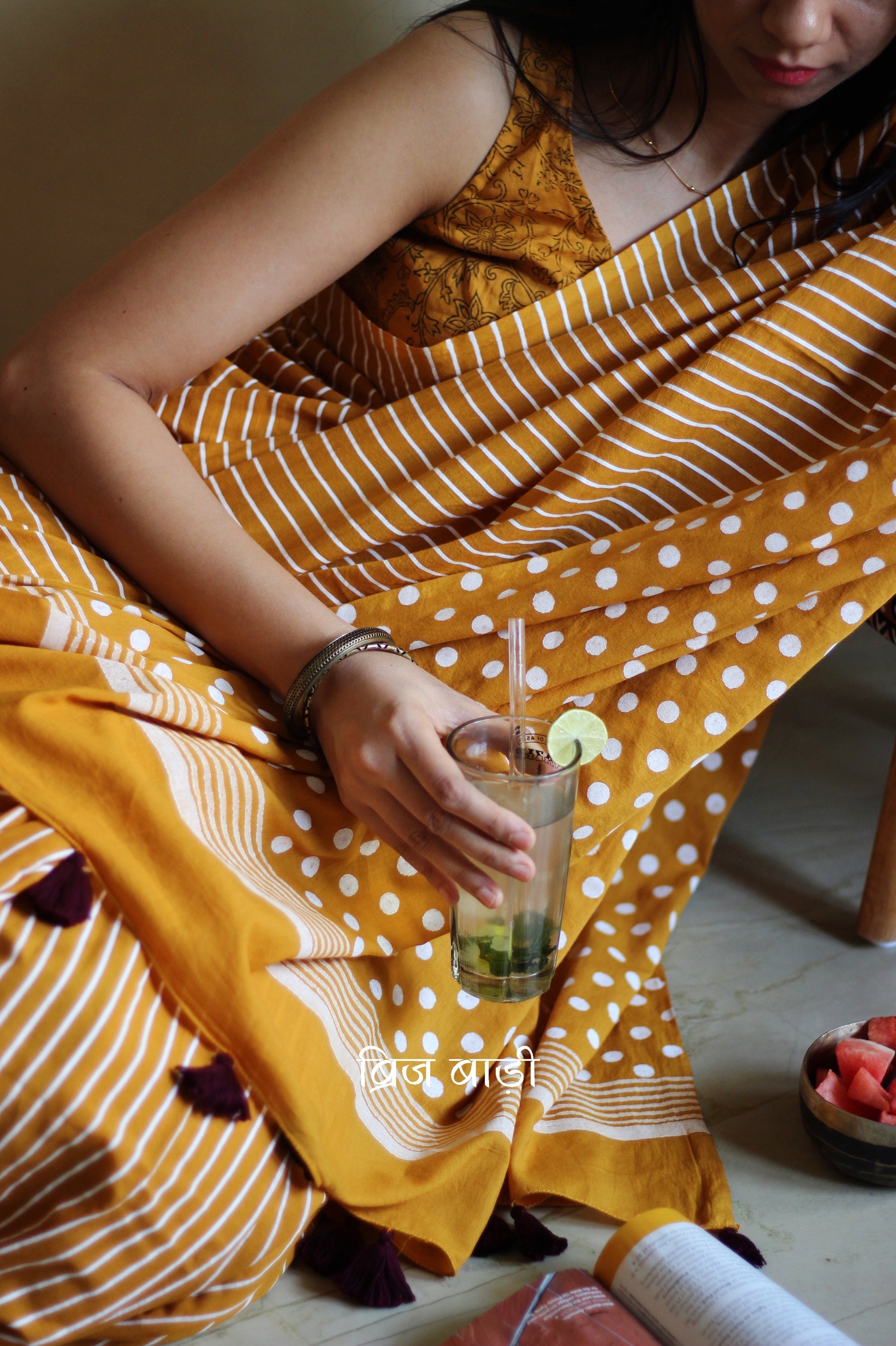Yellow cotton saree by Brij Bari with bold hand block printed stripe and polka dot design. Artisan-crafted, breathable fabric with matching blouse piece.

