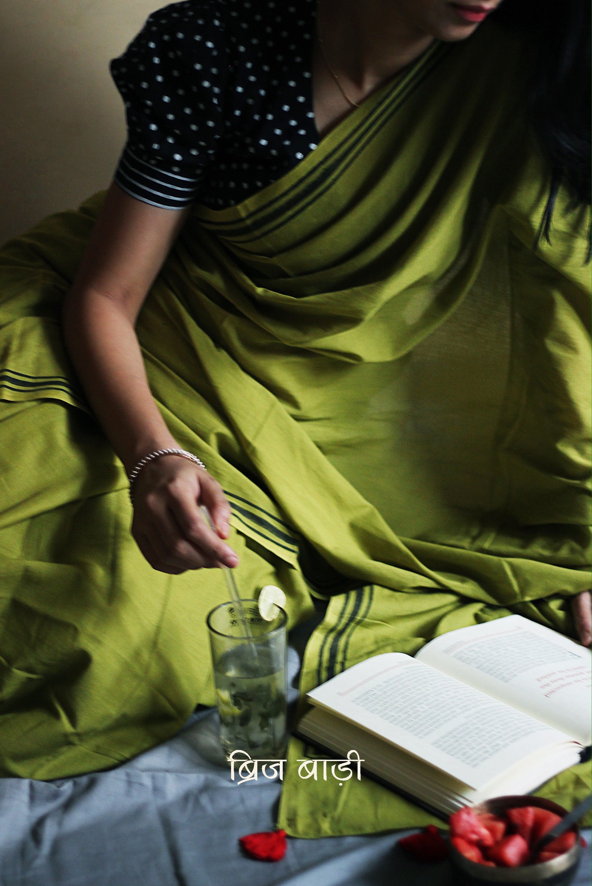 Light green soft and light-weight cotton saree by Brij Bari, crafted with a simple yet elegant black hand block printed stripe border. The saree is adorned with red handmade thread tassels on the pallu, adding a vibrant touch. It comes with a free matching block printed blouse piece, offering a complete handcrafted look. Available in 2 colours, designed for all-day comfort and style, perfect for casual and everyday wear. Free shipping available pan India.