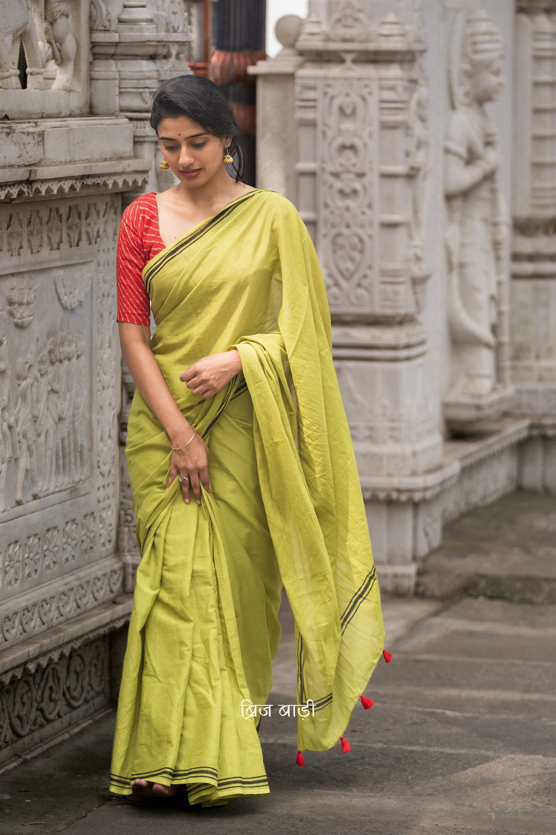 Renowned Social Media Influencer and Actor Sushmita Bhat in our Phalguni saree. Light green soft and light-weight cotton saree by Brij Bari, crafted with a simple yet elegant black hand block printed stripe border. The saree is adorned with red handmade thread tassels on the pallu, adding a vibrant touch. It comes with a free matching block printed blouse piece, offering a complete handcrafted look. Available in 2 colours, designed for all-day comfort and style, perfect for casual and everyday wear. 