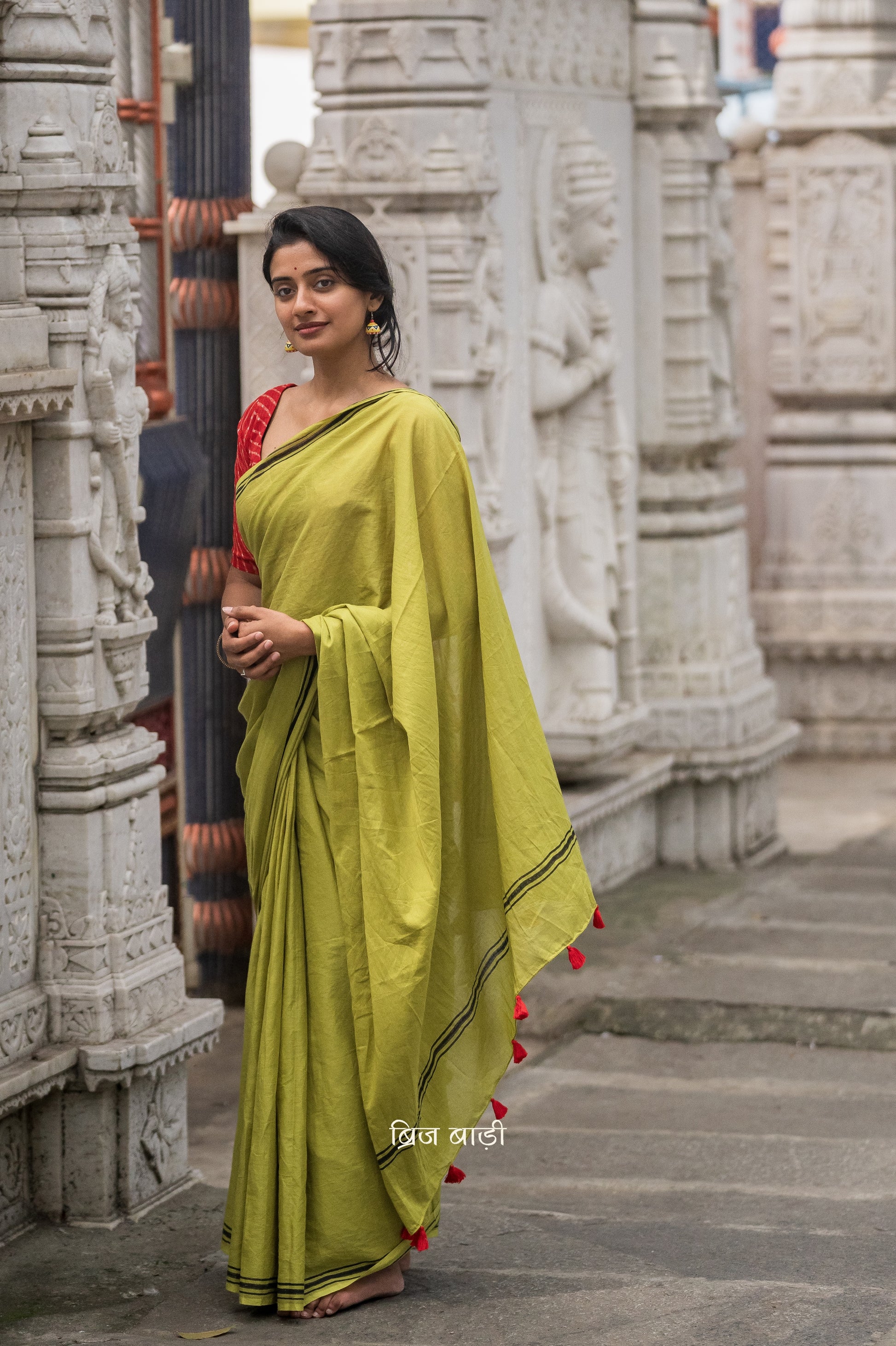Renowned Social Media Influencer and Actor Sushmita Bhat in our Phalguni saree. Light green soft and light-weight cotton saree by Brij Bari, crafted with a simple yet elegant black hand block printed stripe border. The saree is adorned with red handmade thread tassels on the pallu, adding a vibrant touch. It comes with a free matching block printed blouse piece, offering a complete handcrafted look. Available in 2 colours, designed for all-day comfort and style, perfect for casual and everyday wear. 