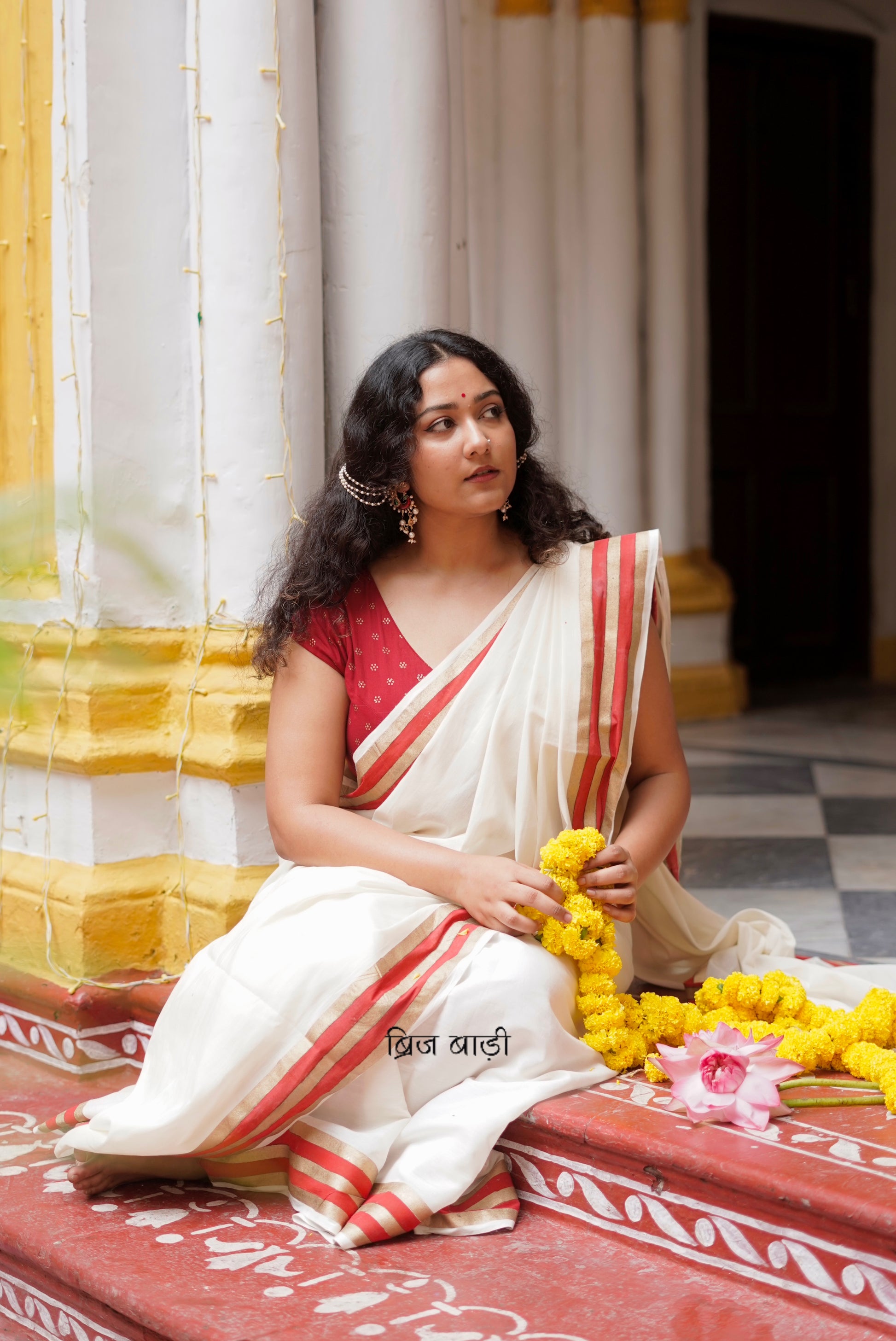 Saraswati off-white cotton saree with hand block printed gold and red stripe border and handmade thread tassels detailing on palla