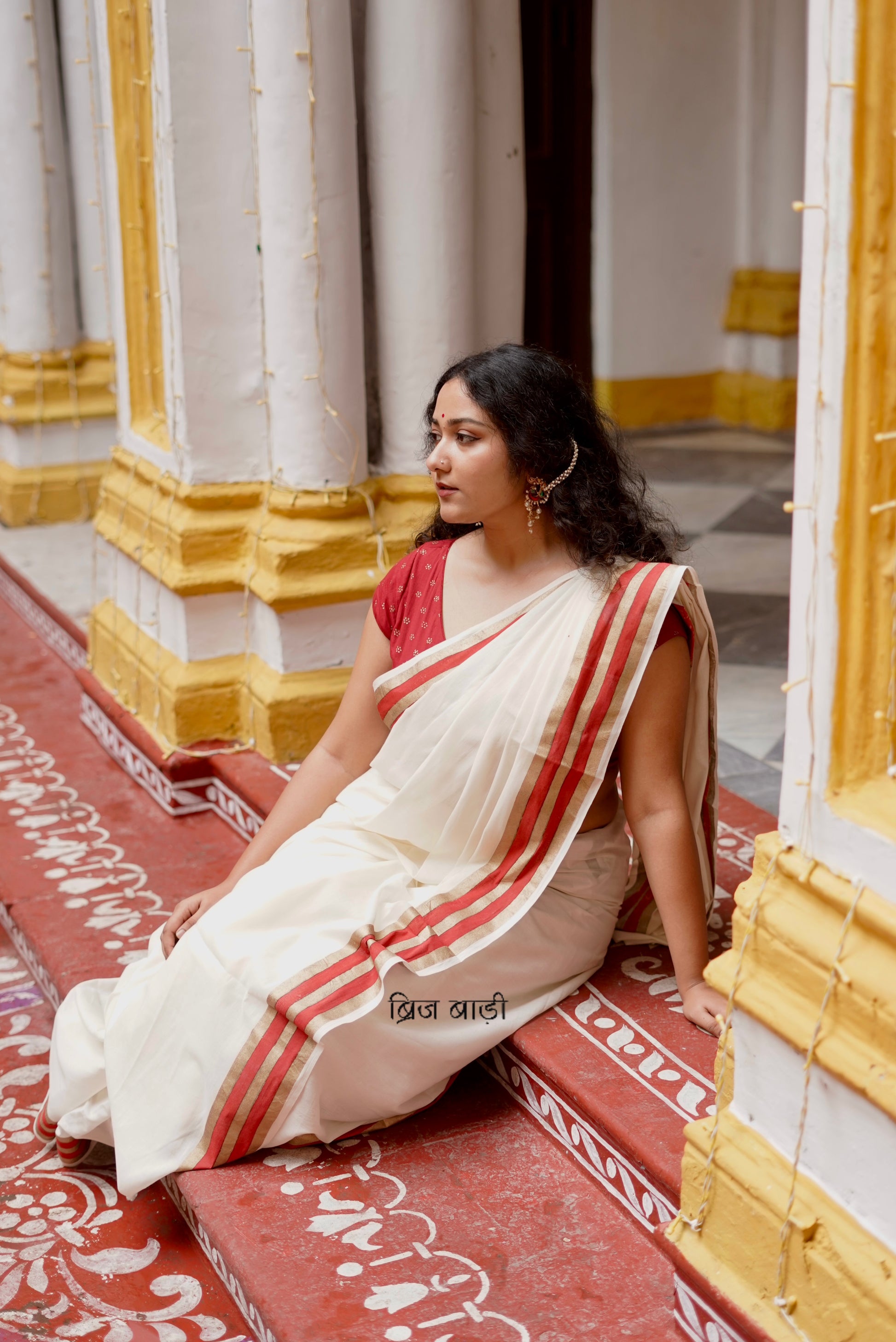 Saraswati off-white cotton saree with hand block printed gold and red stripe border and handmade thread tassels detailing on palla