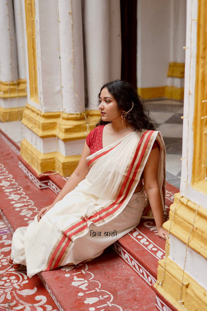 Saraswati off-white cotton saree with hand block printed gold and red stripe border and handmade thread tassels detailing on palla