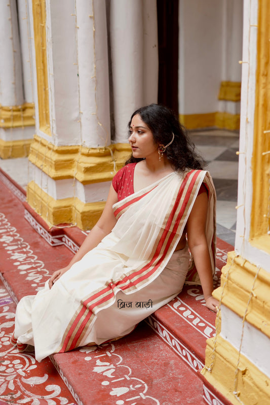 Saraswati off-white cotton saree with hand block printed gold and red stripe border and handmade thread tassels detailing on palla