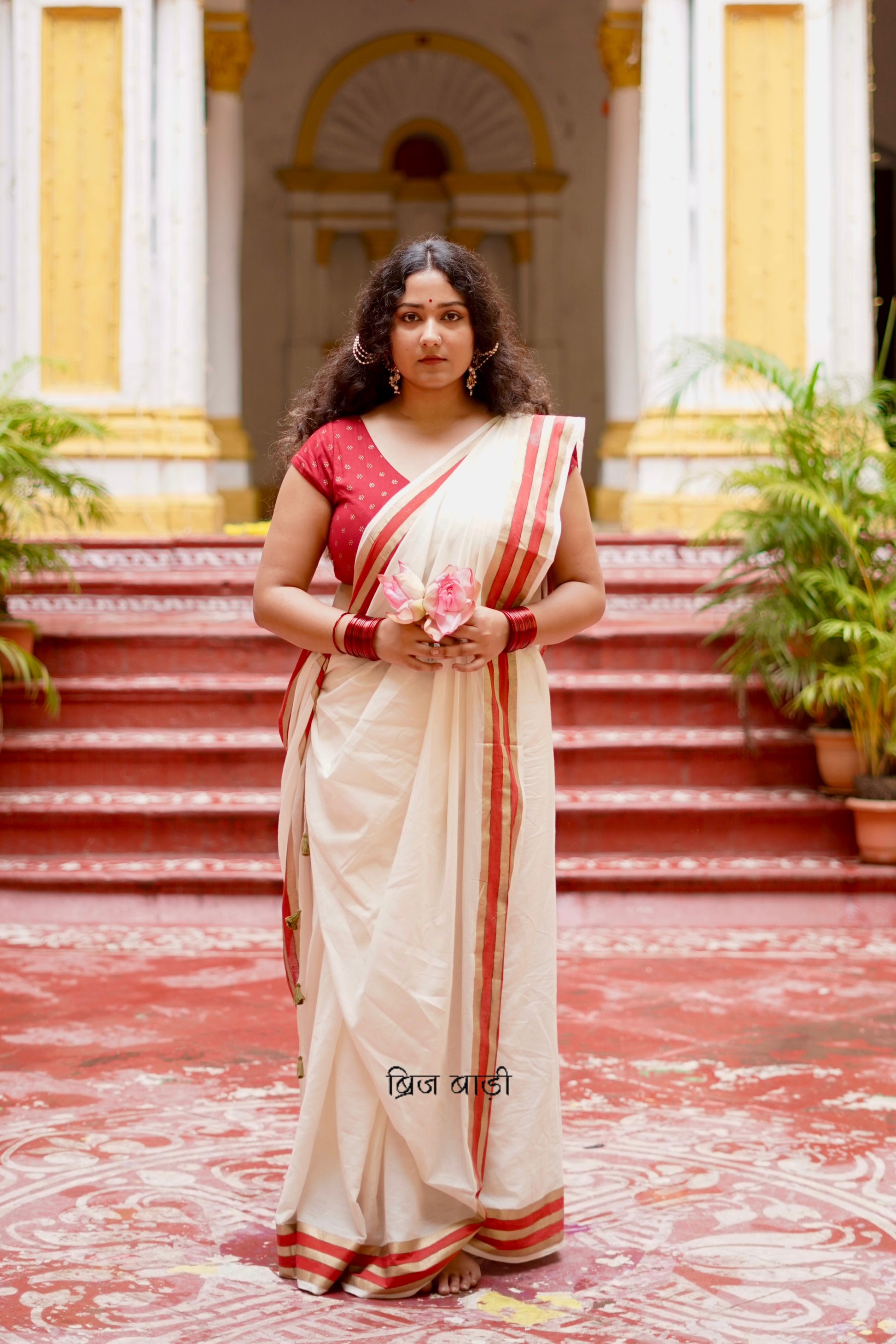 Saraswati off-white cotton saree with hand block printed gold and red stripe border and handmade thread tassels detailing on palla