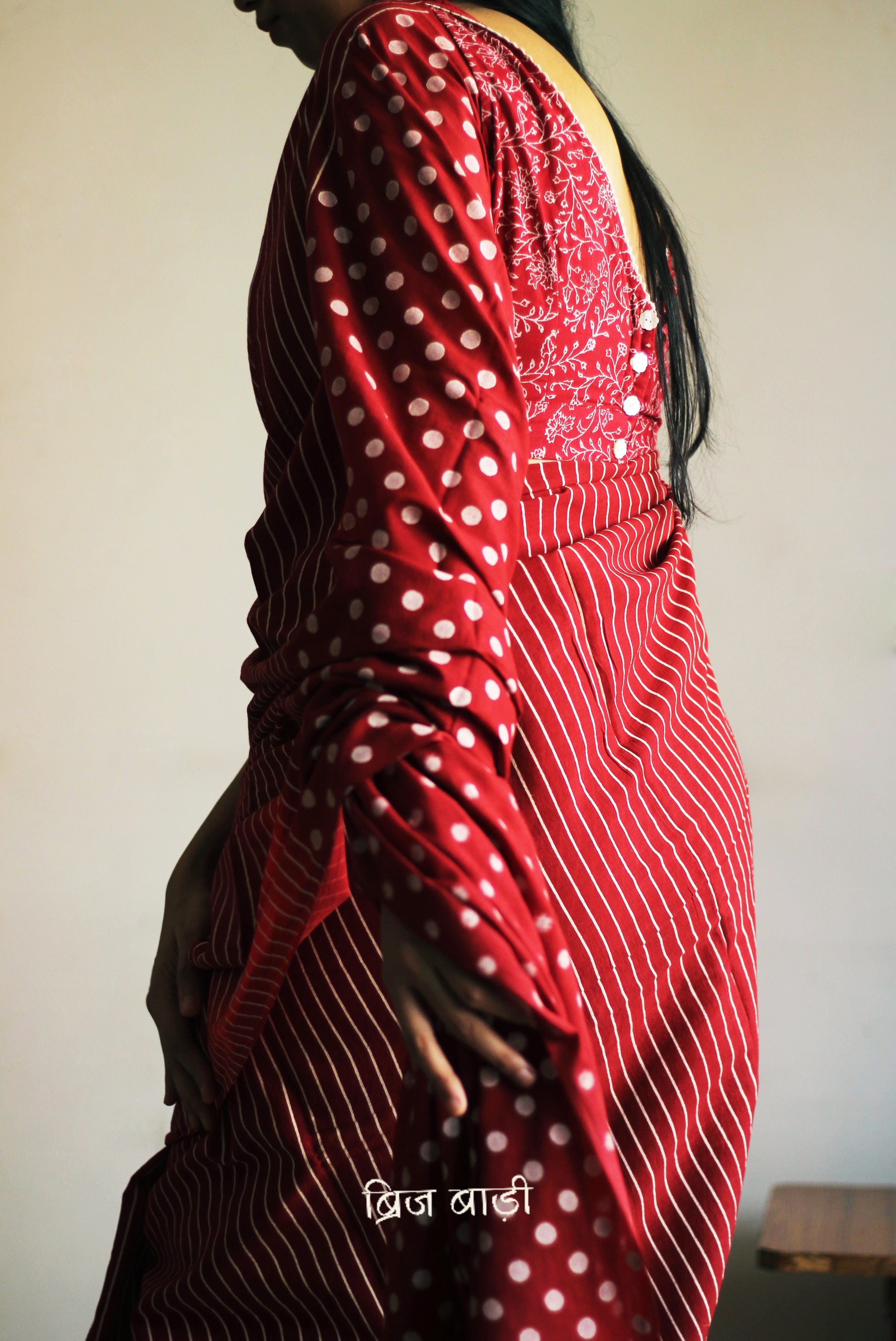 Deep red cotton saree by Brij Bari with bold hand block printed stripe and polka dot design. Artisan-crafted, breathable fabric with matching blouse piece.