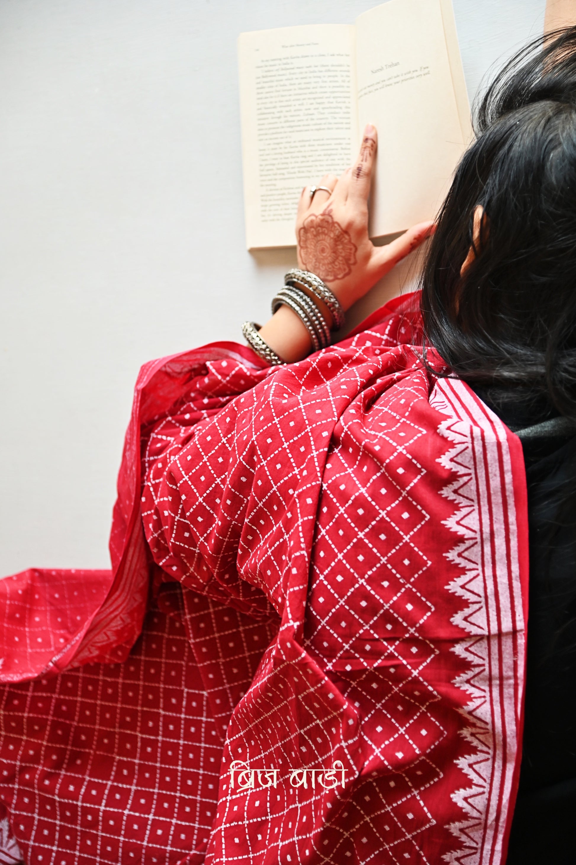 Deep red soft and light-weight cotton dupatta by Brij Bari, featuring a striking geometrical pattern hand block printed in  white,adding a bold modern touch to a classic silhouette. Made from breathable, airy cotton fabric, this dupatta is perfect to pair with a variety of suits, kurtas, or everyday ethnic ensembles, lending a handcrafted, artisanal elegance. The pallu is finished with rich mustard handmade thread tassels, providing a warm contrast and a playful, traditional flair.