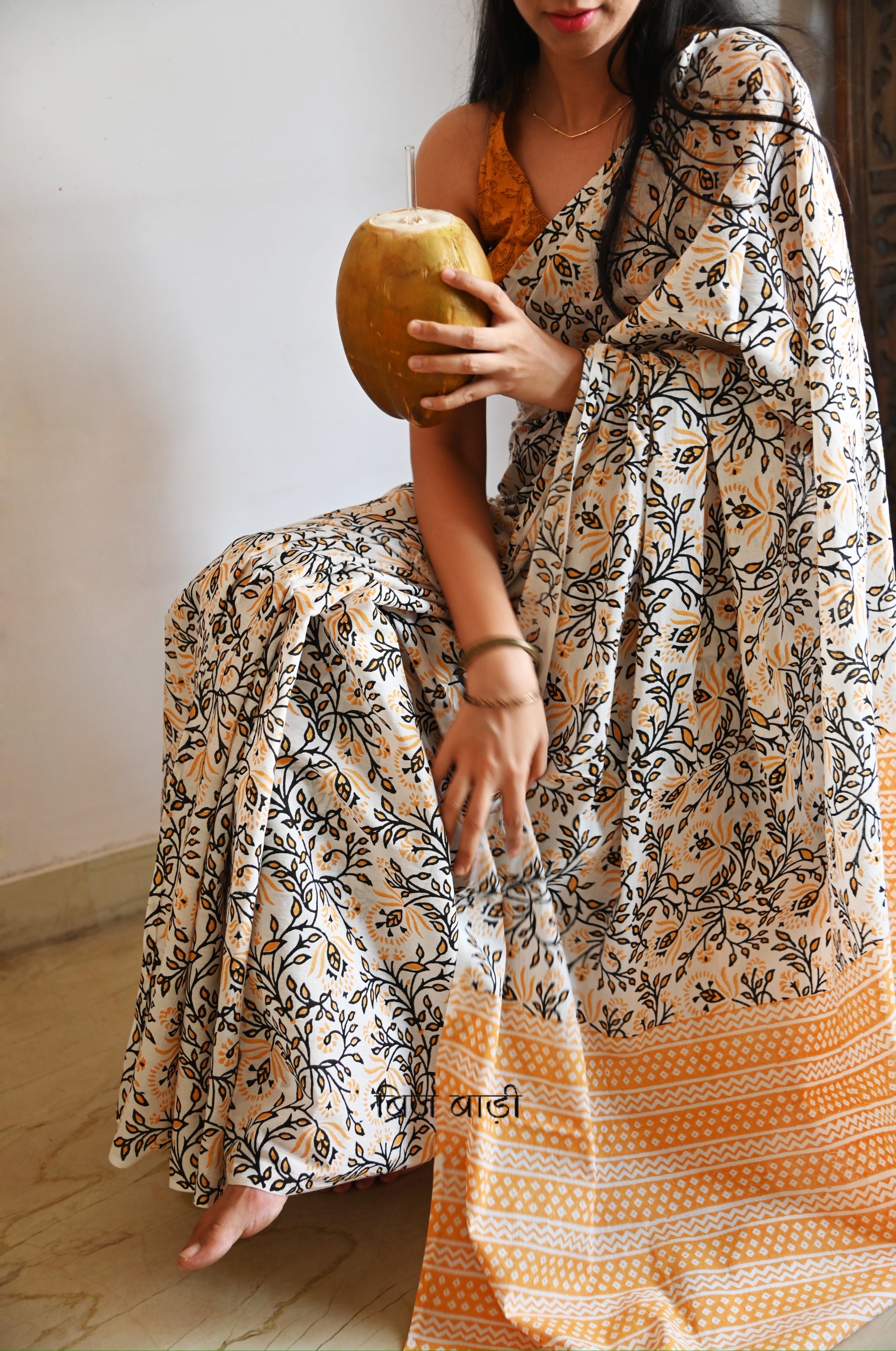 Yellow cotton saree with floral hand block prints, artisan- handcrafted with handmade thread tassels on pallu. Comes with a soft, breathable printed blouse piece.