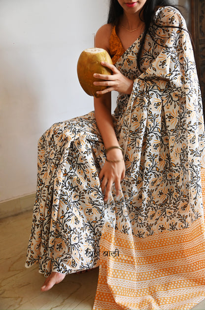 Yellow cotton saree with floral hand block prints, artisan- handcrafted with handmade thread tassels on pallu. Comes with a soft, breathable printed blouse piece.