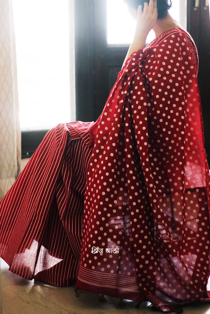 Deep Red cotton saree with bold hand block printed stripes and polka dots, artisan-crafted in breathable fabric. Includes matching printed blouse piece.

