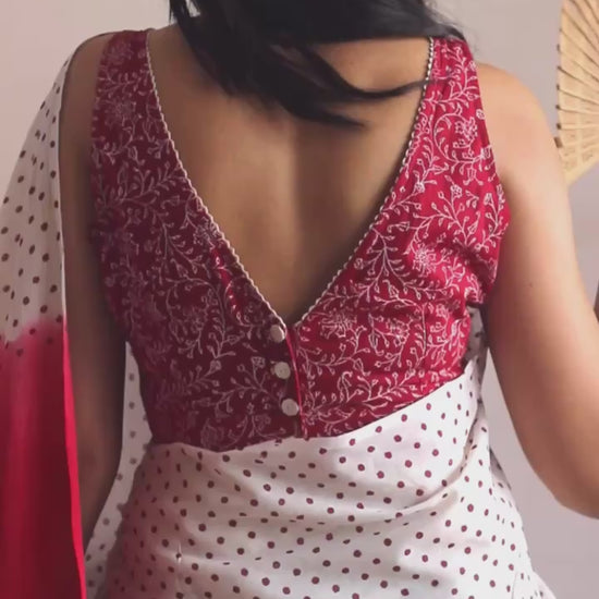 Off-white soft and light-weight cotton saree by Brij Bari, featuring deep red ombre pallu and small retro-style polka dot hand block prints. Accented with handcrafted mustard thread tassels on the pallu for a touch of artisanal charm. Includes a free matching hand block printed blouse piece. A timeless piece combining elegance, tradition, and comfort—crafted by Brij Bari’s skilled artisans.