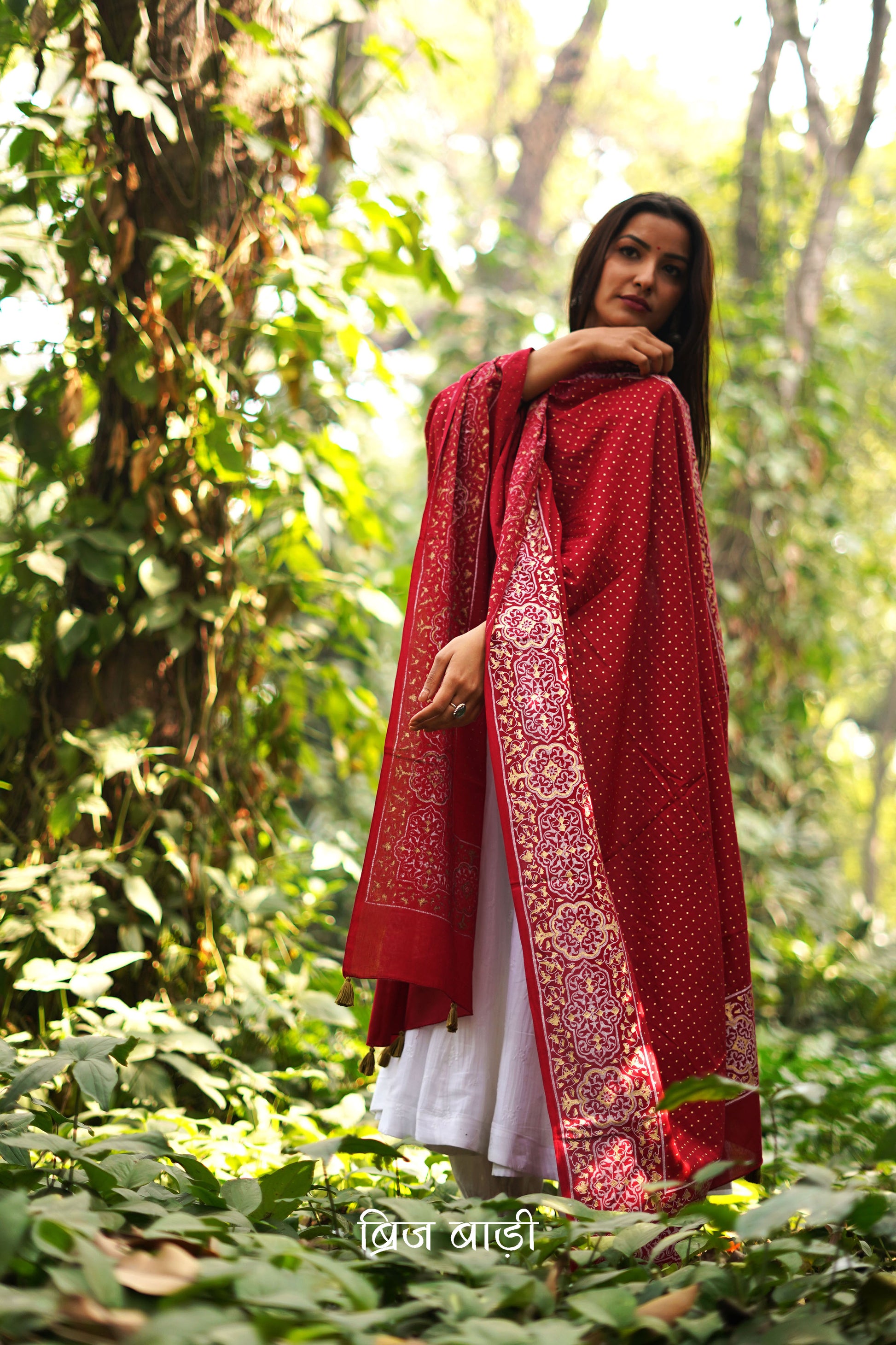 Red buttery soft and lightweight cotton dupatta by Brij Bari, hand block printed with a beautiful golden and ivory pattern that adds a festive yet refined touch. Accented with handmade olive green thread tassels on both ends of the pallu, this dupatta is crafted for comfort and elegance. A versatile piece to pair effortlessly with daily or festive suits. Free shipping pan India.