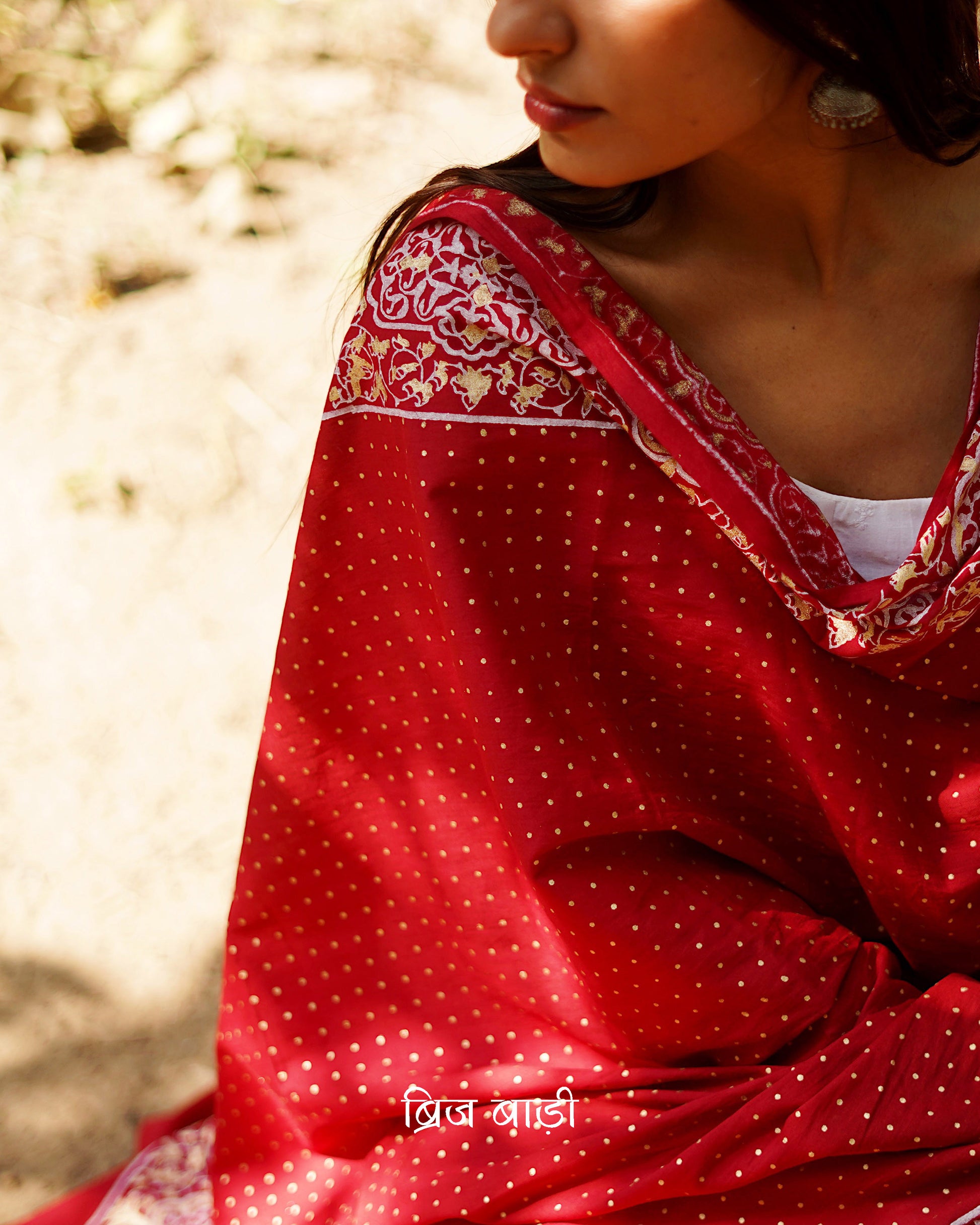 Red buttery soft and lightweight cotton dupatta by Brij Bari, hand block printed with a beautiful golden and ivory pattern that adds a festive yet refined touch. Accented with handmade olive green thread tassels on both ends of the pallu, this dupatta is crafted for comfort and elegance. A versatile piece to pair effortlessly with daily or festive suits. Free shipping pan India.